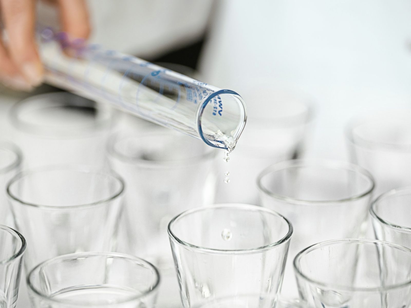 Gefäße werden mit einer Flüssigkeit in einem Reagenzglas befüllt