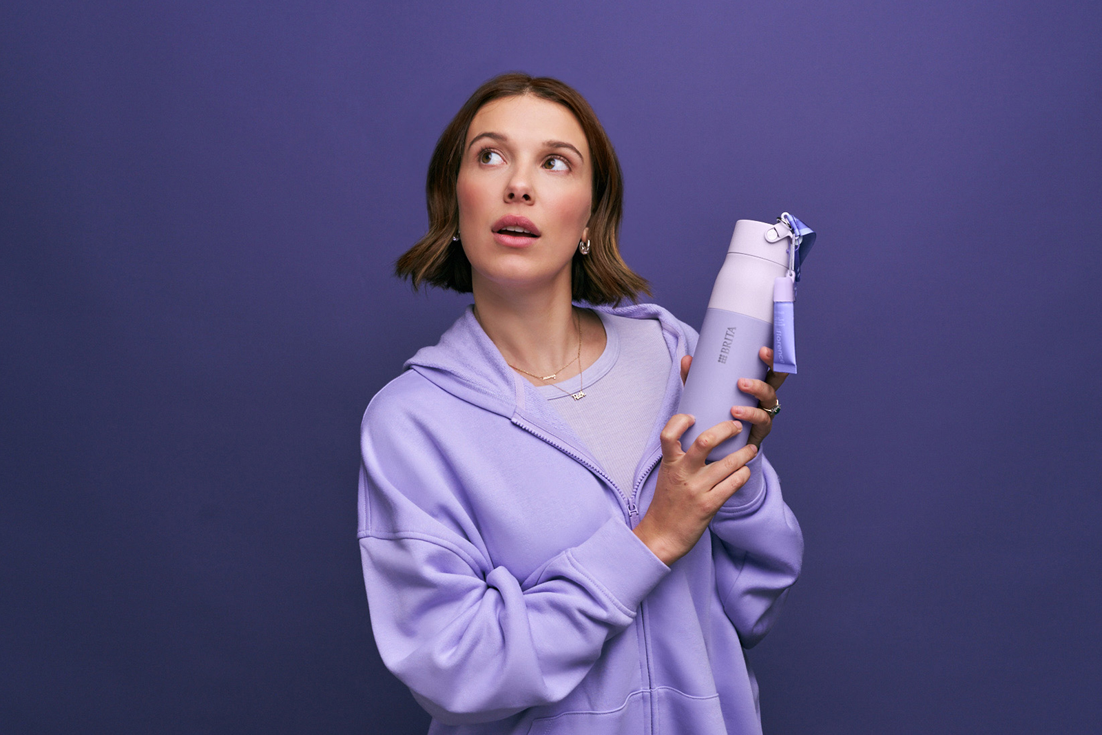 Millie Bobby Brown in lila Sweatshirt hält florence by mills x BRITA LARQ Flasche