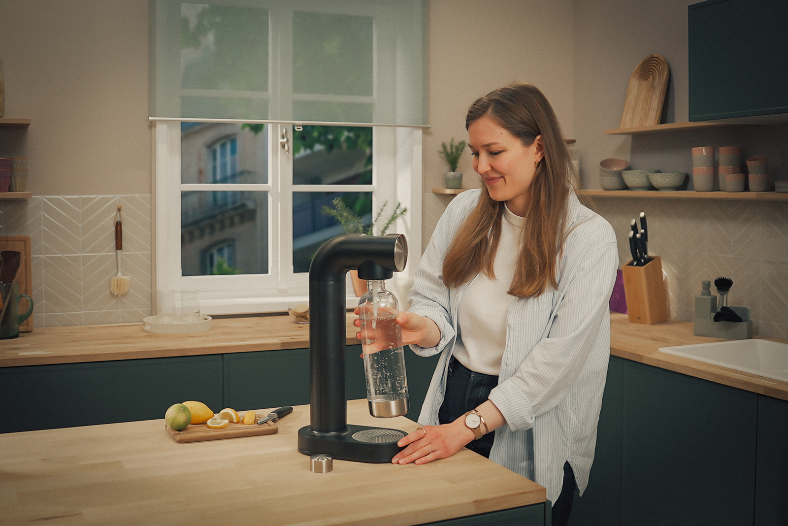 Junge Frau bedient den schwarzen sodaONE Wassersprudler Junge Frau bedient den schwarzen sodaONE Wassersprudler