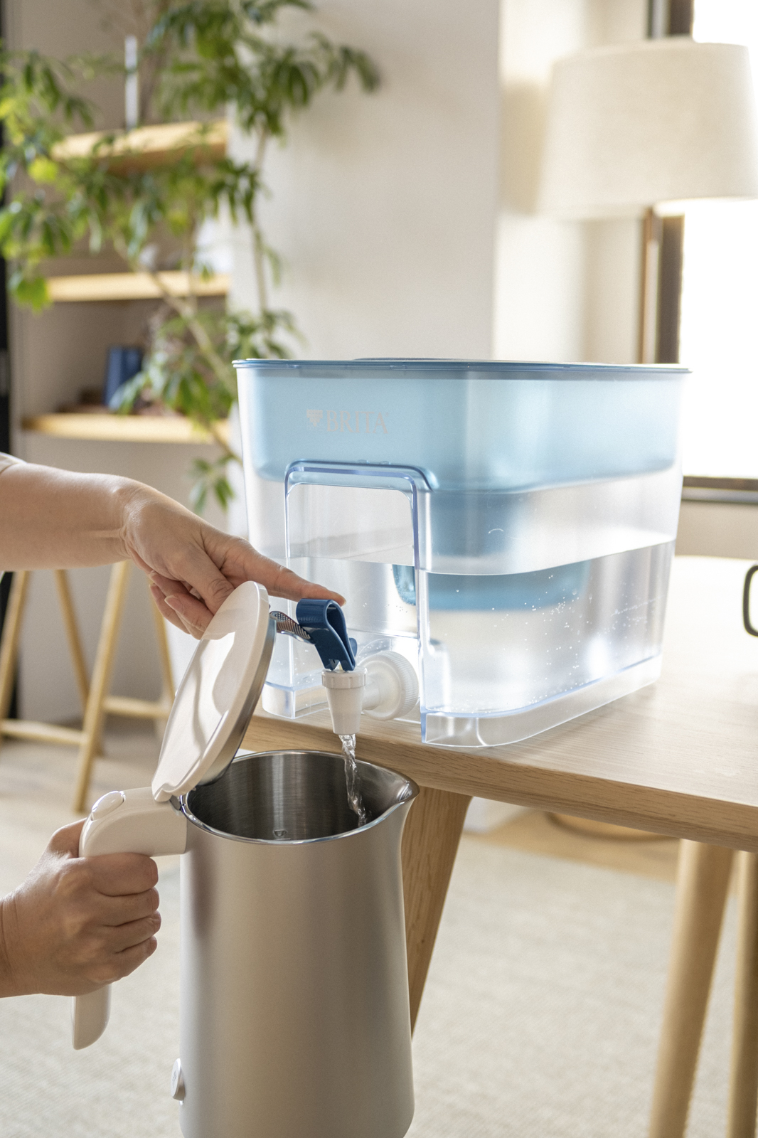 Wasser wird aus BRITA Flow eingeschenkt. Wasser wird aus dem BRITA Flow Tischwasserfilter in einen Wasserkocher gezapft.