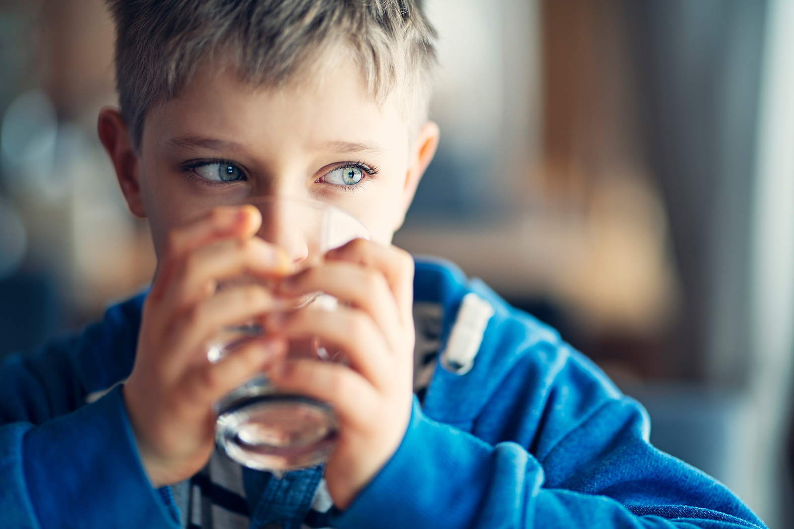 Ein Junge trinkt ein Glas Wasser
