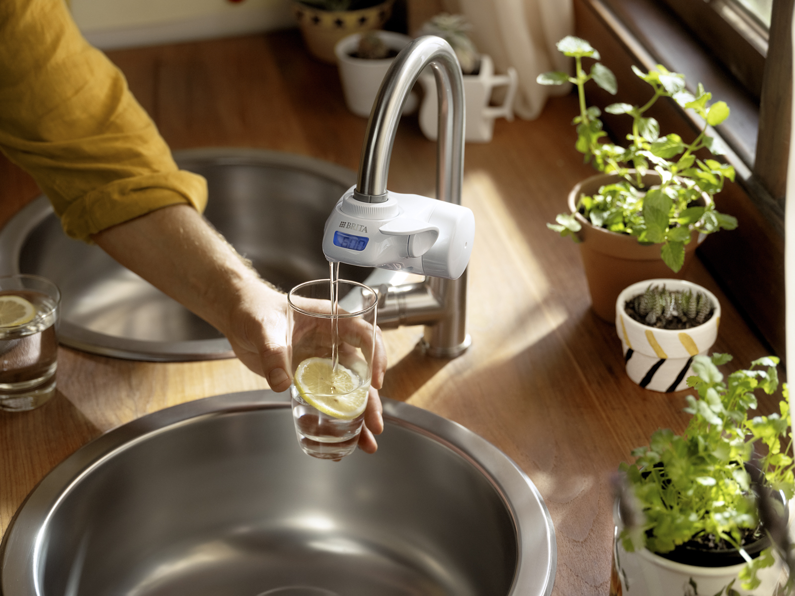 Frau füllt am ON TAP V-MF ein Glas Wasser Eine Frau füllt am ON TAP V-MF ein Glas BRITA gefiltertes Wasser