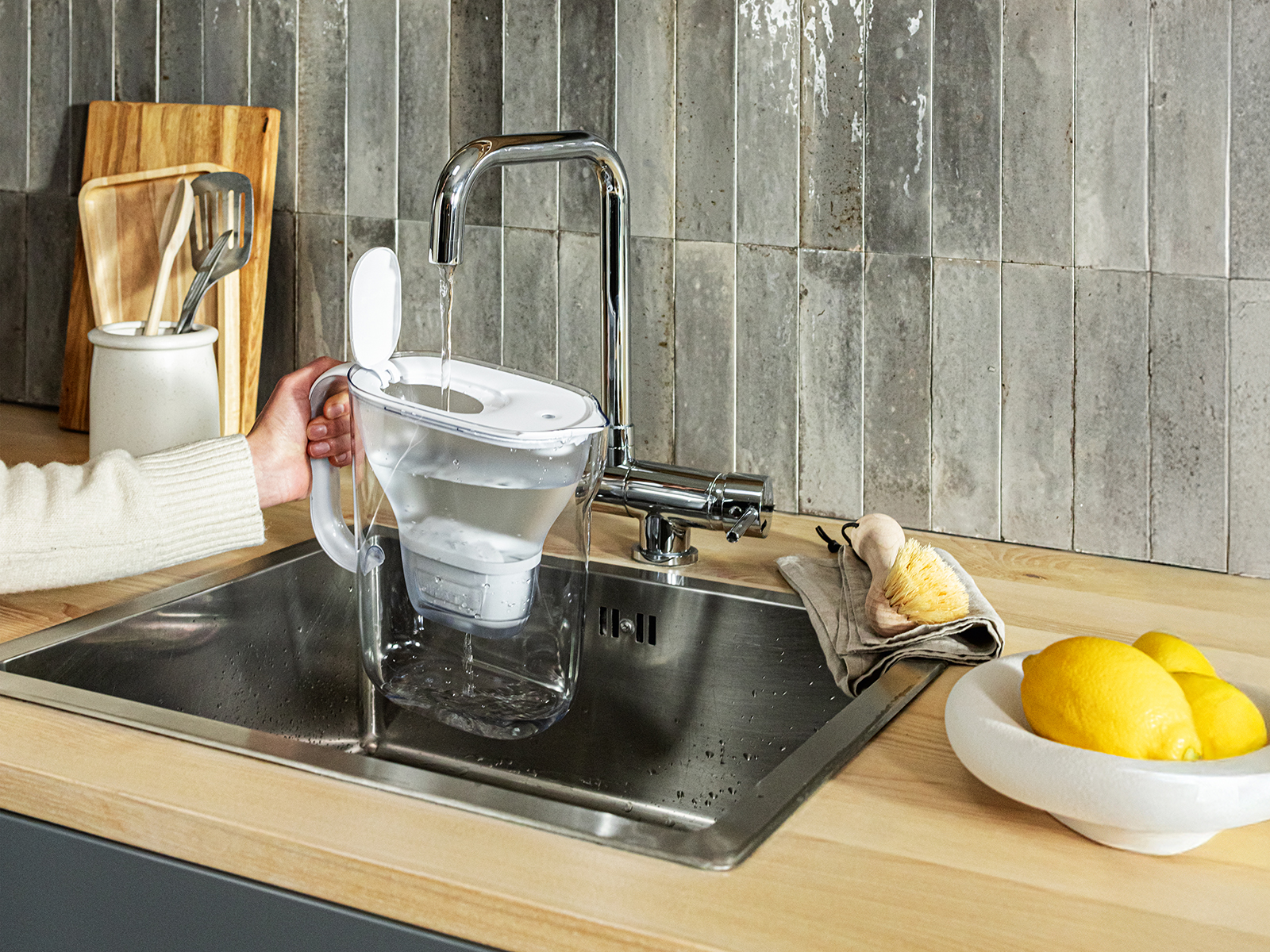 Style Essential White Wasser einfüllen Weiße Kanne wird am Wasserhahn aufgefüllt.