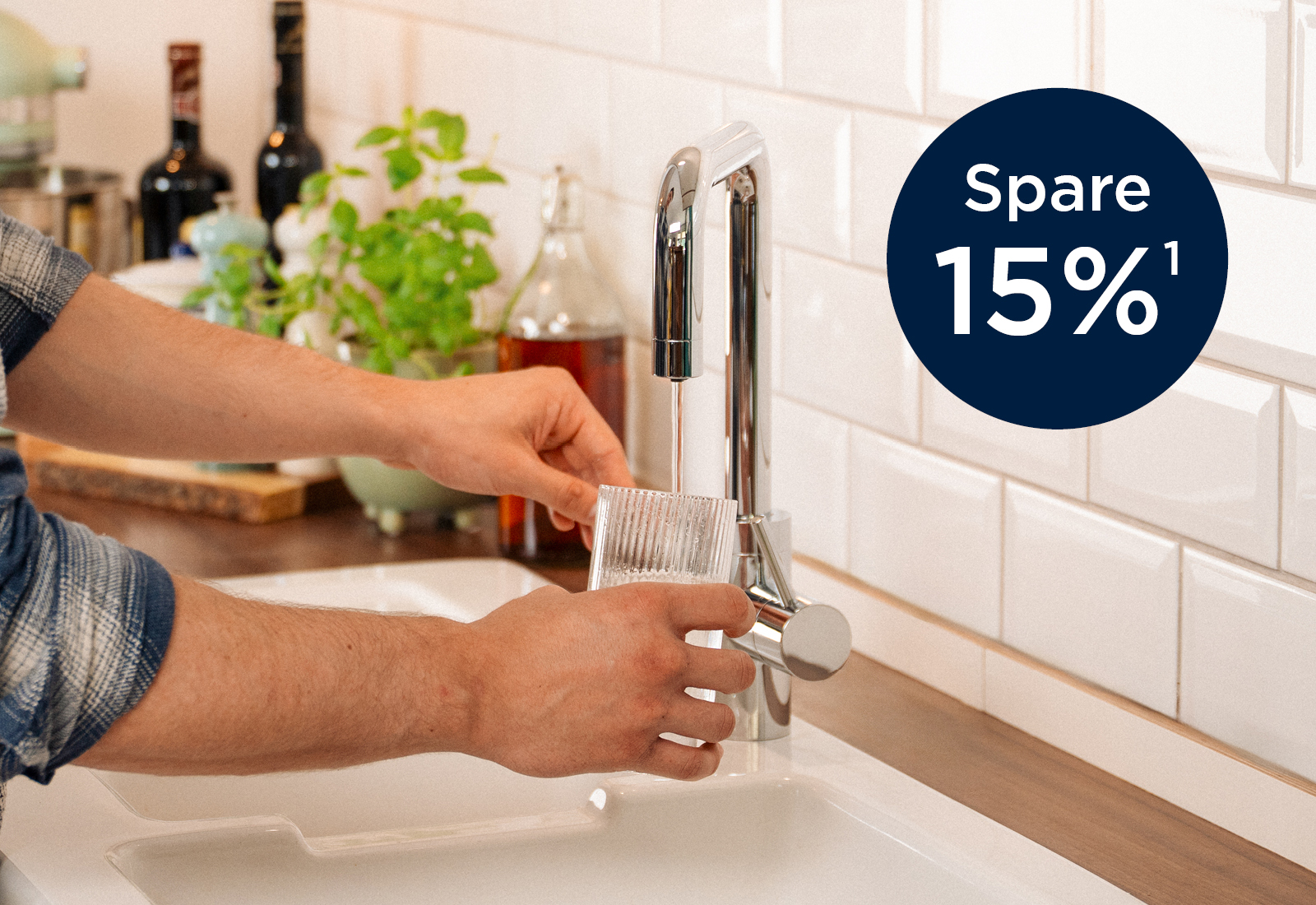 Mann befüllt Wasserglas mit Wasserhahn yource pro select Ein Mann füllt sich ein Glas mit Wasser am Wasserhahn yource pro select, mit Störer 15% sparen