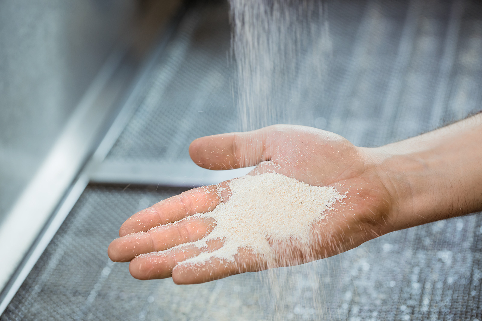 Eine Wasserfilter-Kartusche wird geleert Der Inhalt einer Wasserfilter-Kartusche wird in eine geöffnete Hand geleert