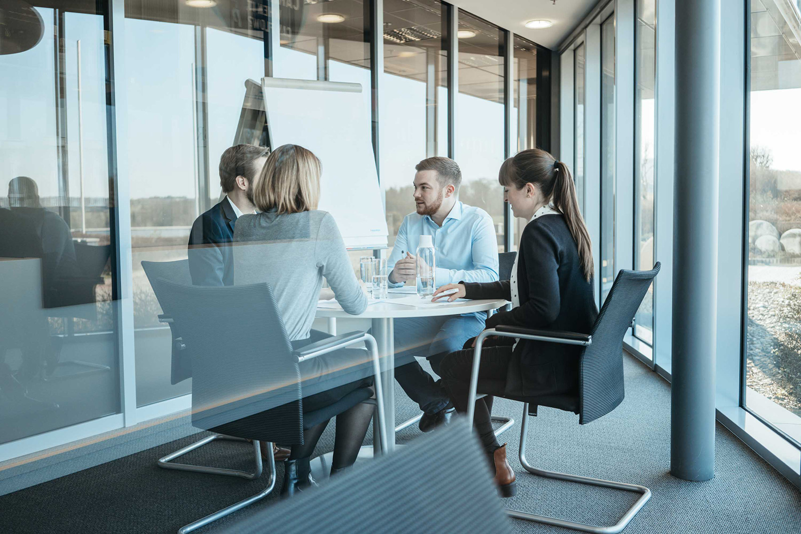 Kolleg:innen sitzen an einem Konferentisch Kolleg:innen sitzen an einem Konferenztisch