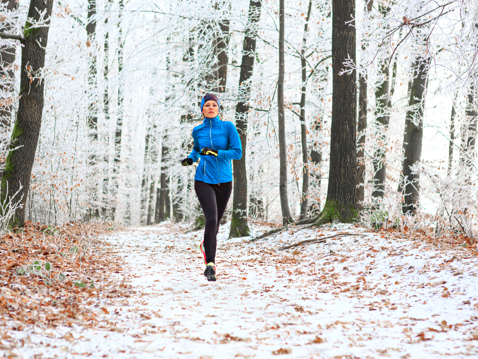 Trailrunning im Winter Trail Läuferin im Winterwald bei Schnee