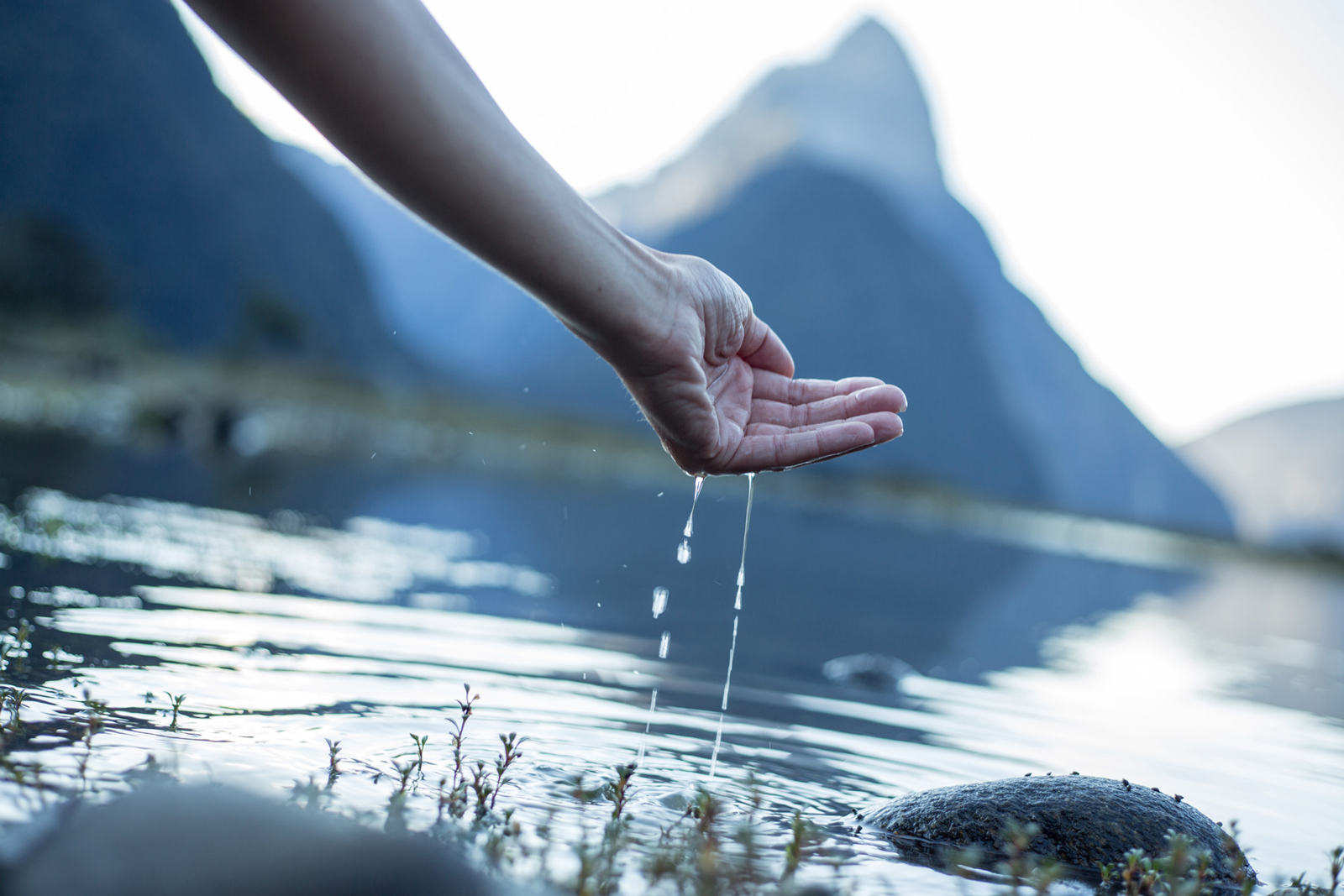 Symboldbild für den Weltwassertag: Eine Hand schöpft Wasser aus einem Bergsee