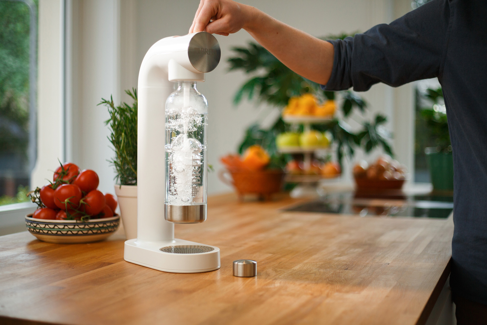Wassersprudler BRITA sodaONE Eine Person sprudelt Wasser auf mit dem Wassersprudler BRITA sodaONE