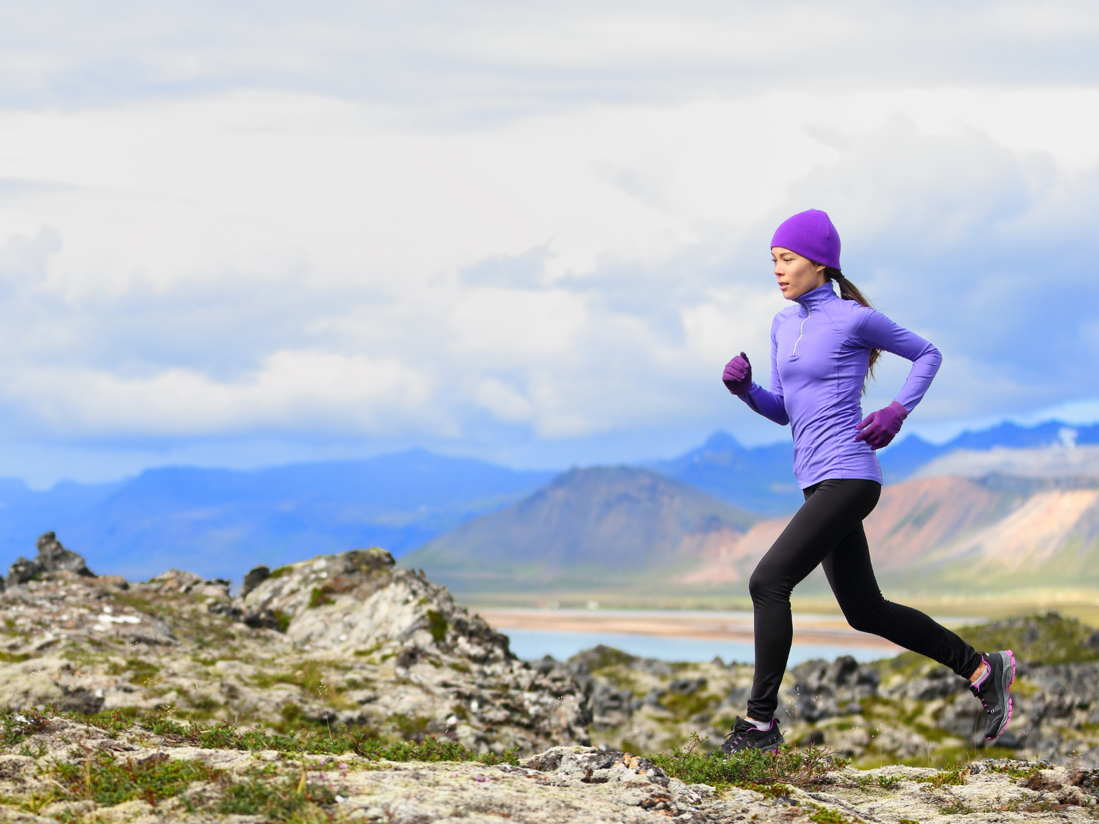 Frau beim Trailrunning im Herbst mit Berg und Bergsee-Panorama