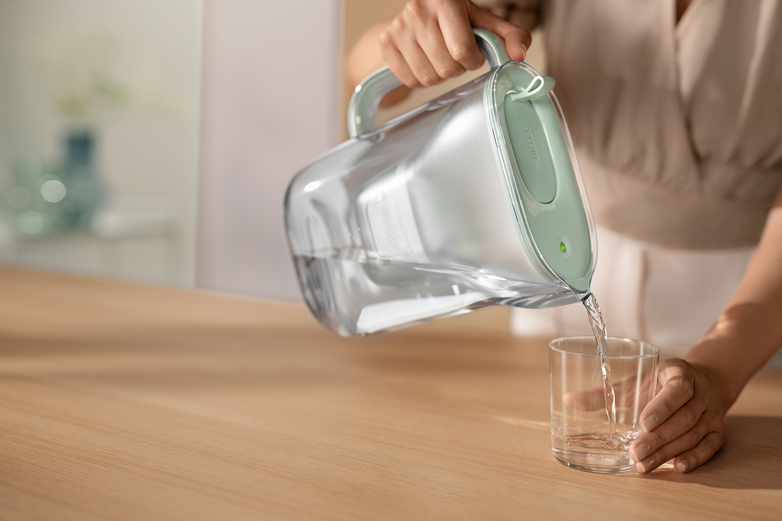 Eine Frau schenkt Wasser ein aus Style eco. Eine Frau schenkt Wasser ein aus Style eco.