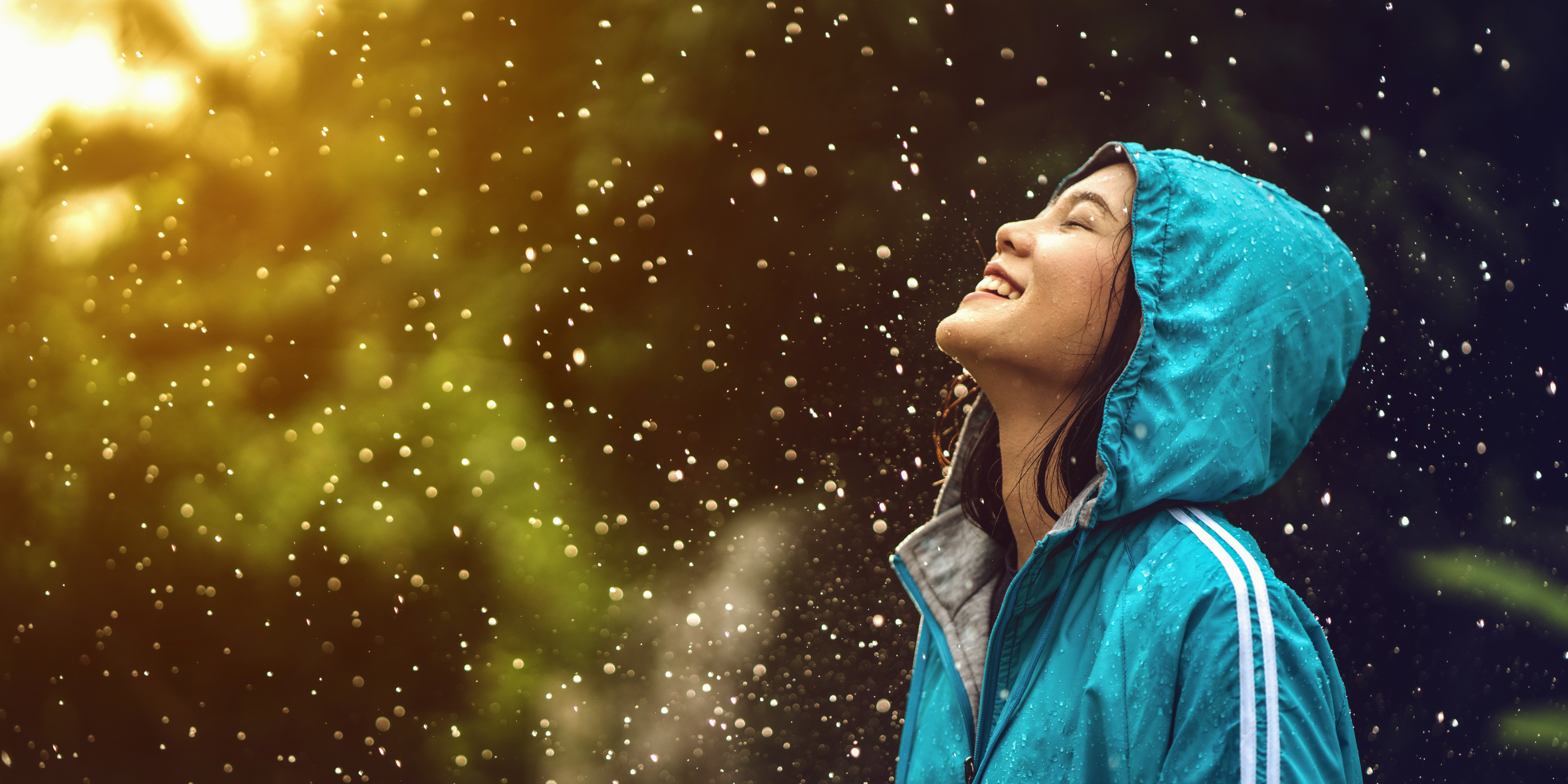 Trail Runnerin genießt den Moment im Regen, während die Sonne wieder scheint