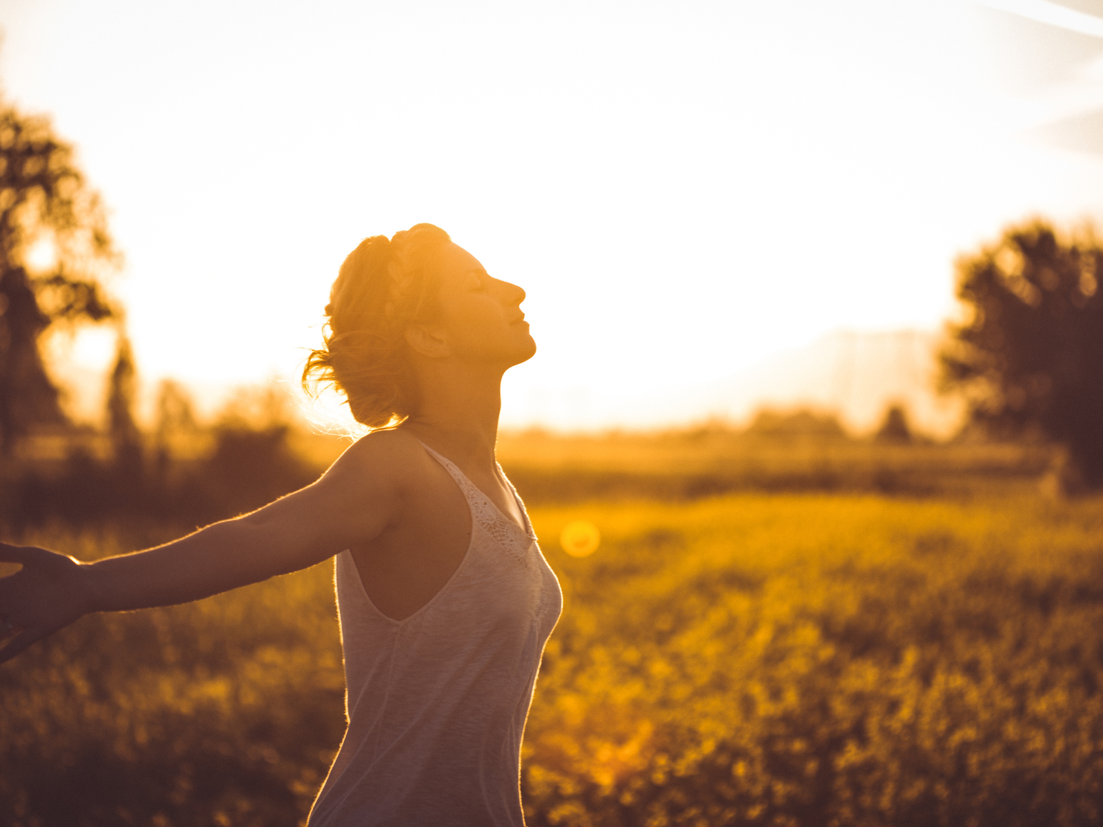 Frau führt einfache Atemübungen in der Natur aus