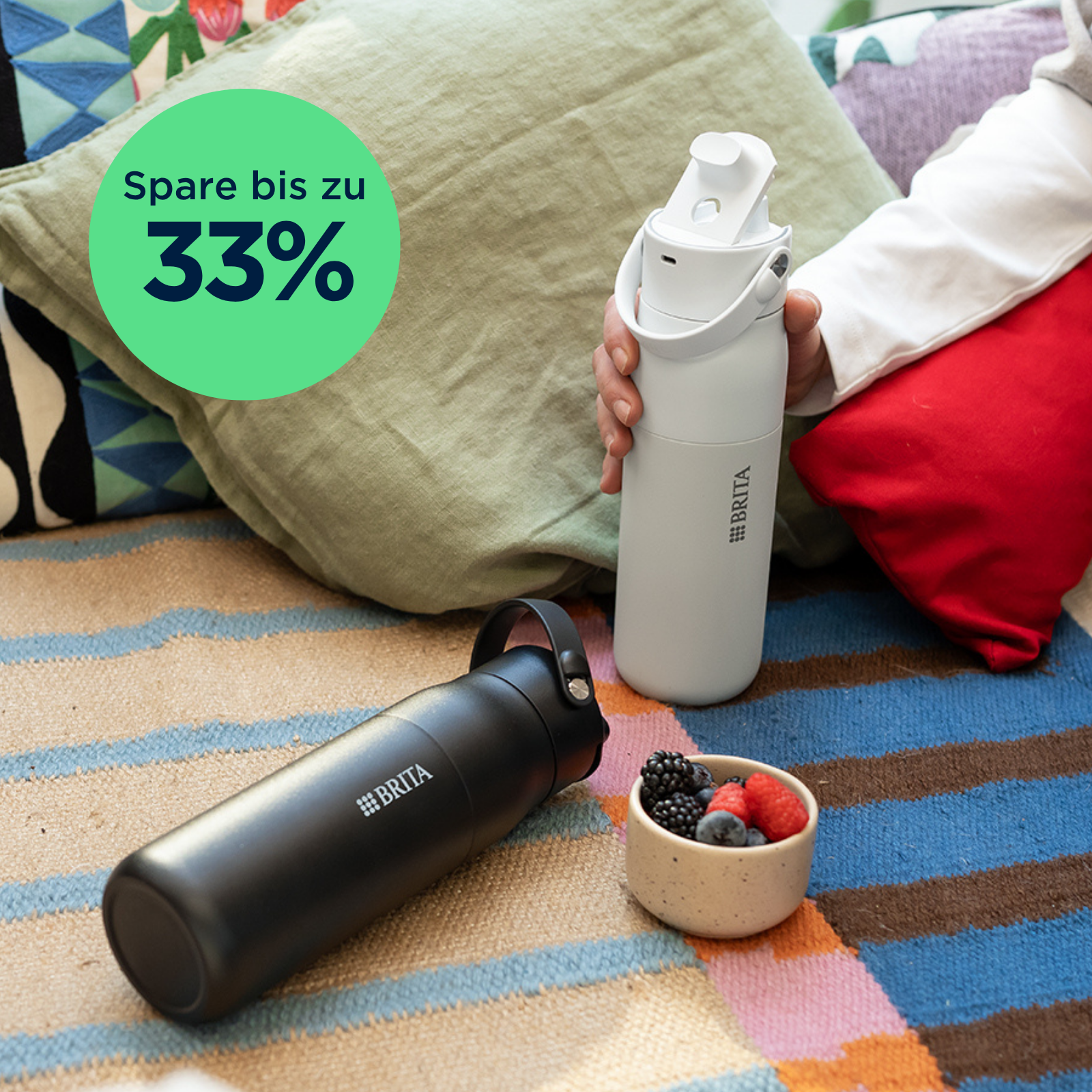 Schwarze und weiße BRITA LARQ iQ Wasserfilterflasche auf einer Couch.