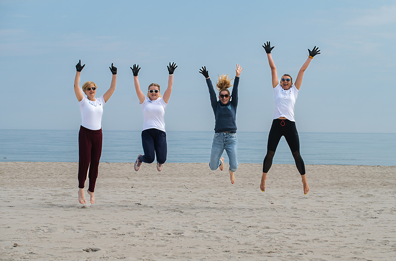 BRITA Mitarbeiter:innen springen bei einer Cleanup-Aktion in Polen am Strand in die Luft
