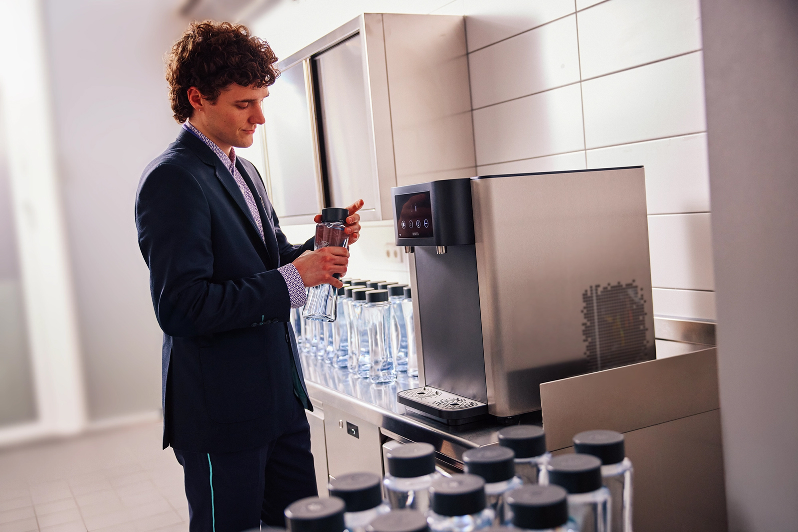 Hotelangestellter füllt Wasserflaschen am BRITA Wasserspender