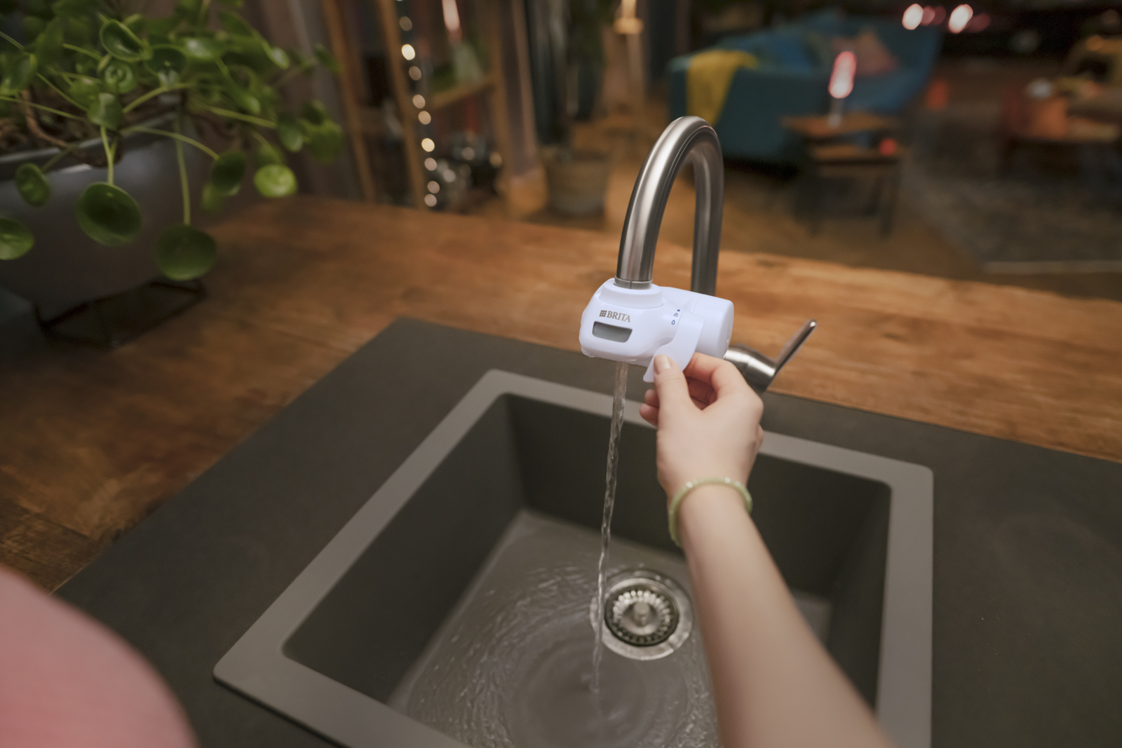 Frau benutzt den BRITA ON TAP Pro V-MF Eine Frau benutzt den BRITA ON TAP Pro V-MF in einer Küche