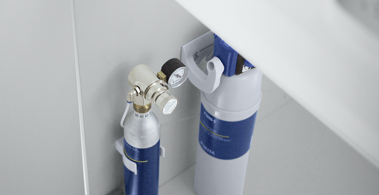 CO2-Zylinder und Filter in einem Unterschrank In einem geöffneten Unterschrank sind ein yource CO2-Zylinder und eine Filterkartusche untergebracht