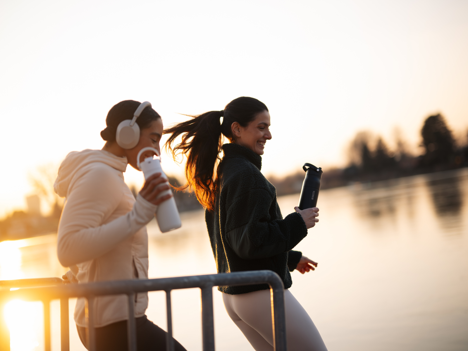 5 Hydration Tipps für deine nächsten Lauf Zwei Frauen bei ihrem Laufen bei Sonnenuntergang mit ihrer BRITA LARQ Essential Trinkflasche