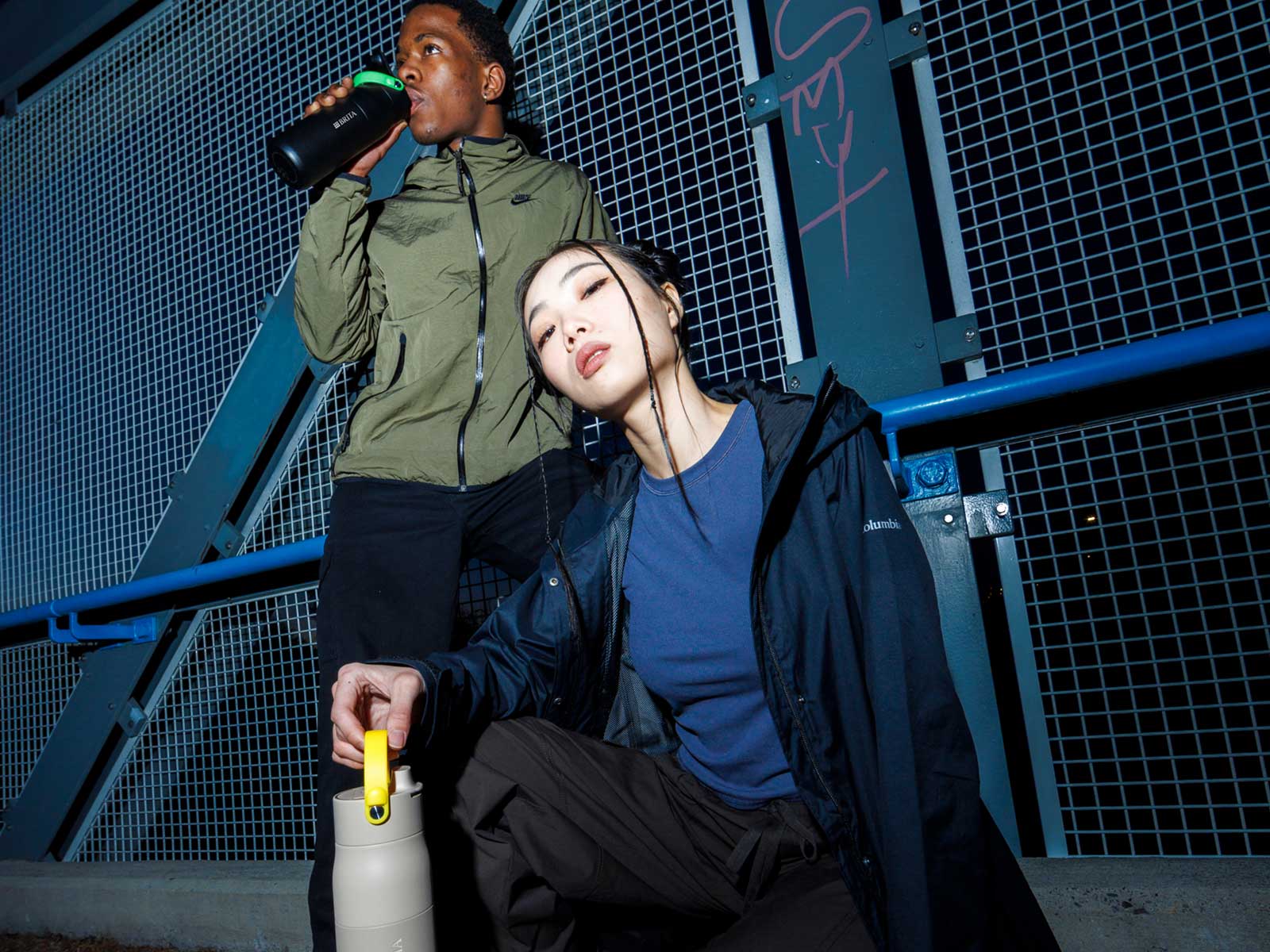 Junge Menschen mit BRITA LARQ Flaschen mit farbigen Griffen Zwei stylische junge Menschen posieren mit BRITA LARQ Flaschen, die ein farbiges Griffband haben.