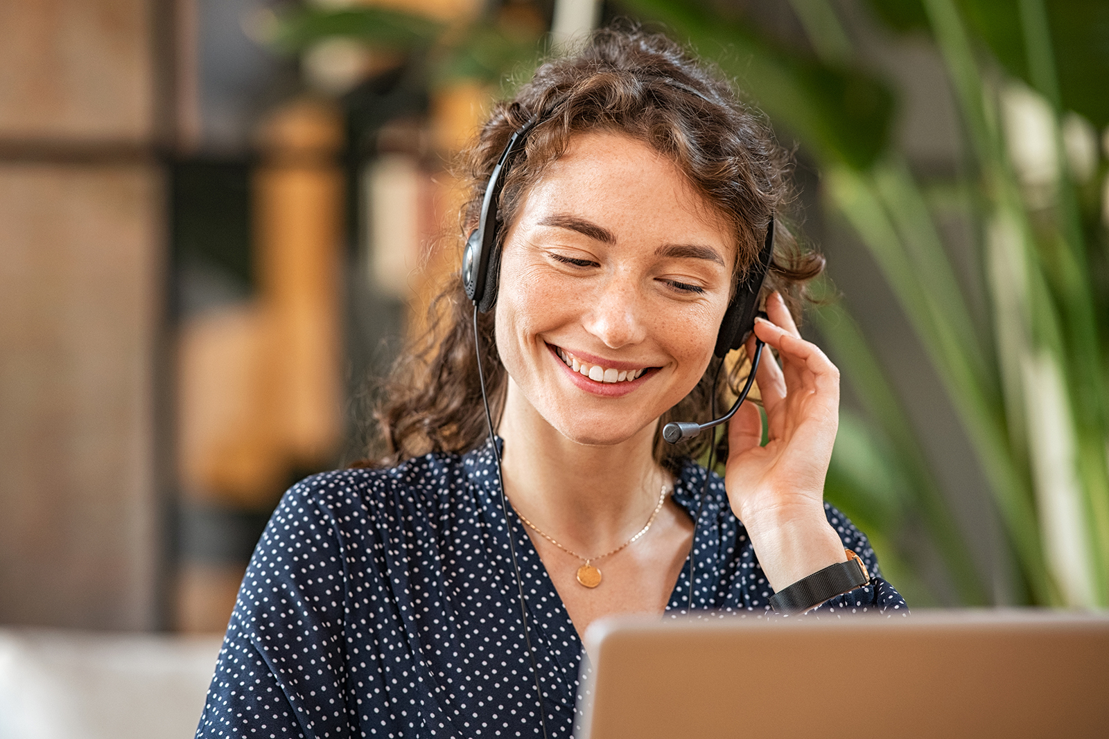 Junge Frau vom Kundenservice telefoniert Eine freundliche junge Frau vom Kundenservice telefoniert