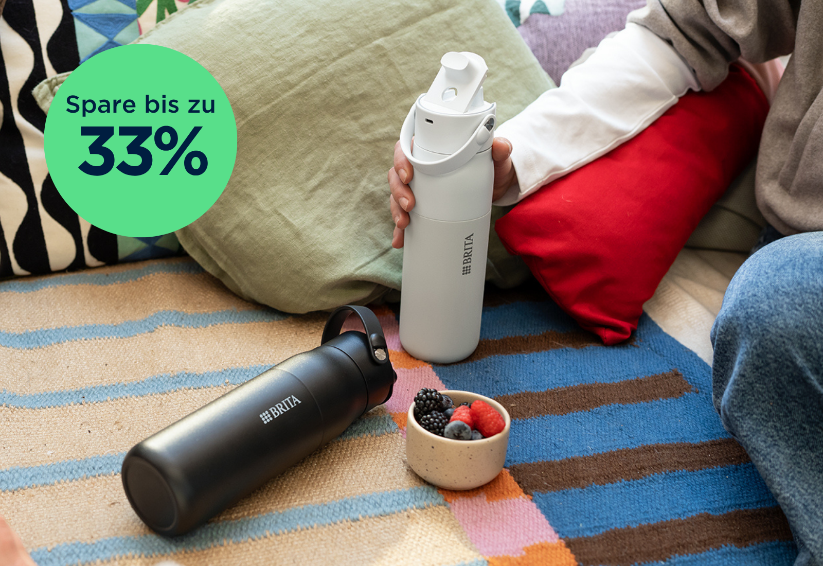 Schwarze und weiße BRITA LARQ iQ Flasche auf Couch Schwarze und weiße BRITA LARQ iQ Wasserfilterflasche auf einer Couch.