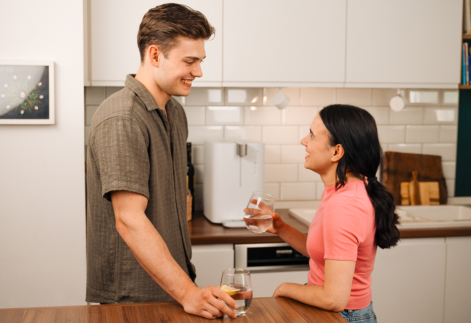 Zwei Personen stehen in einer modernen Küche und trinken Wasser neben einem yource pro top