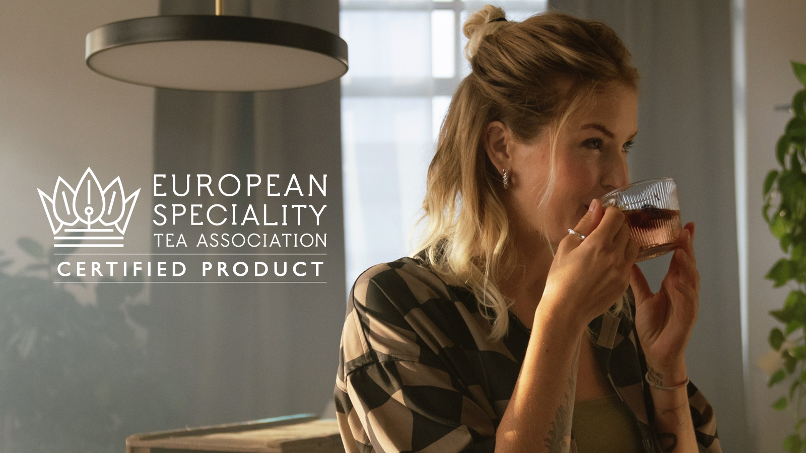 Eine junge Frau trinkt entspannt eine Tasse Tee.