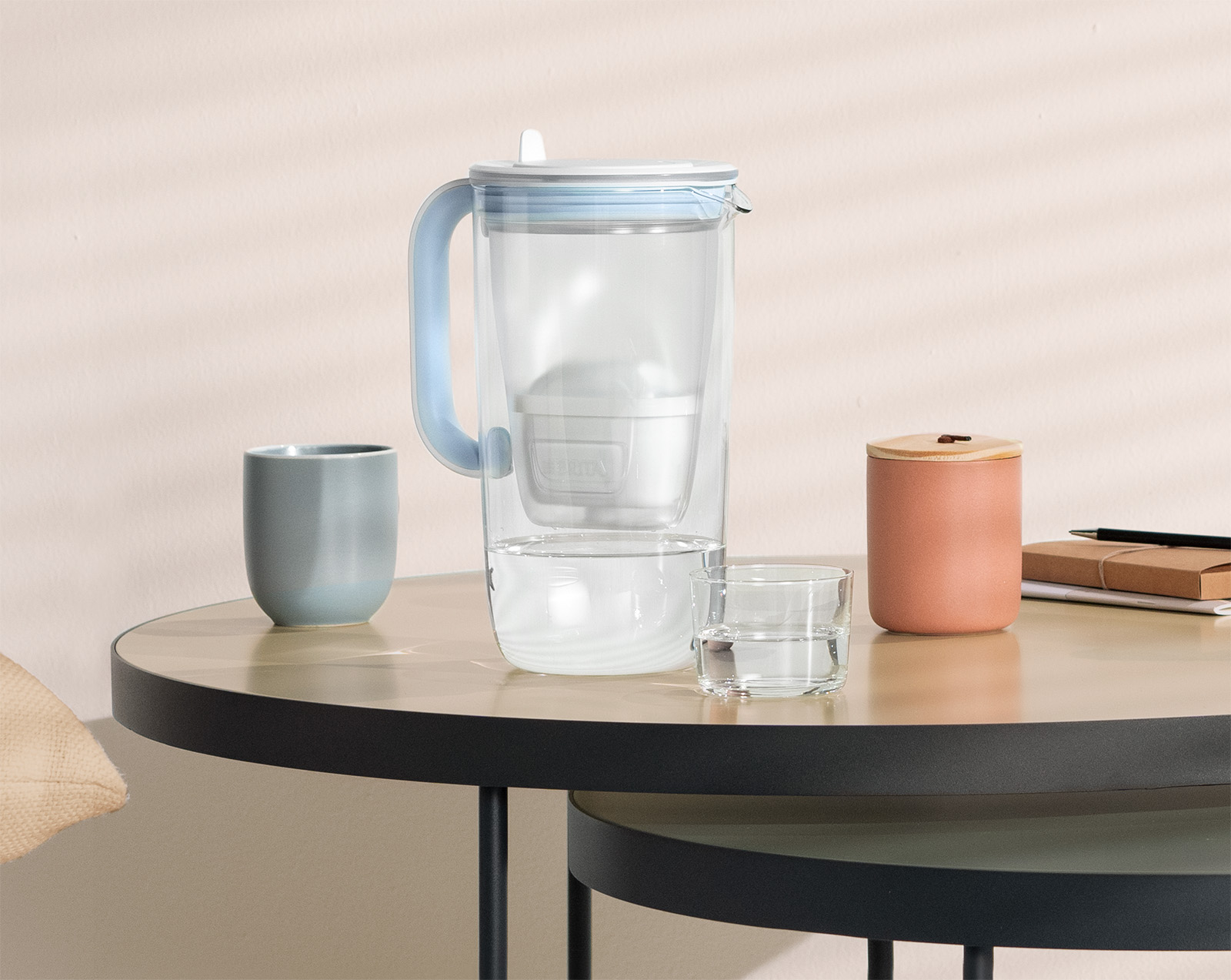 Tischwasserfilter Glas steht auf Beistelltisch Der BRITA Tischwasserfilter Glas in Blau steht auf einem Beistelltisch.