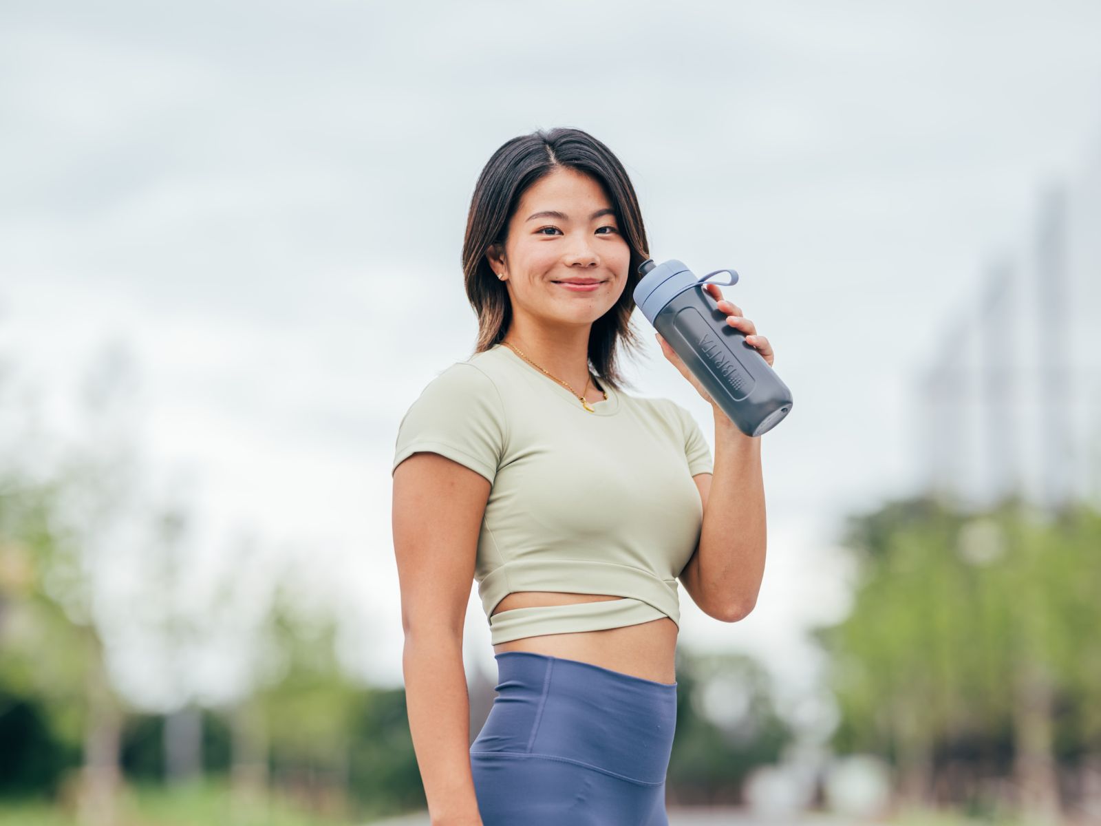 Frau steht mit BRITA Wasserfilterflasche im Freien Frau steht mit BRITA Wasserfilterflasche im Freien