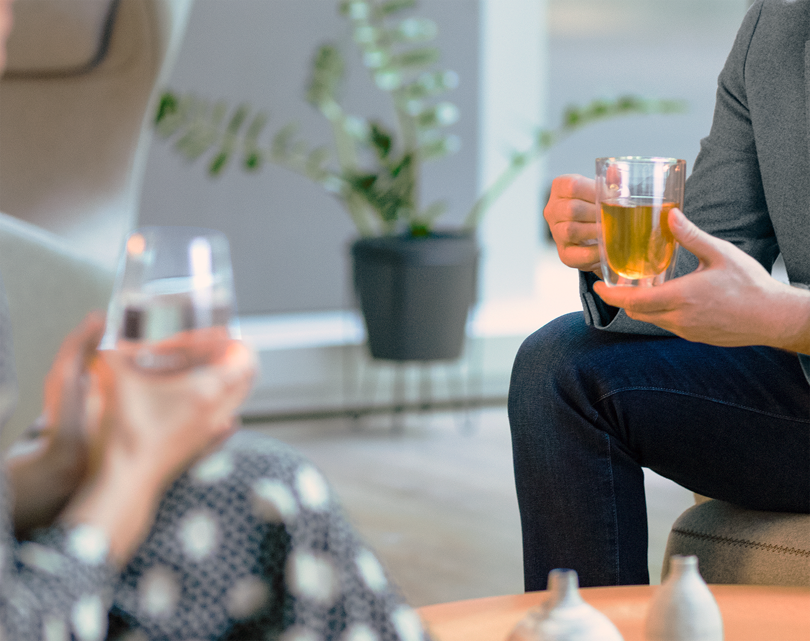 Mann trinkt Tee, Frau trinkt Wasser und sitzen zusammen Mann trinkt Tee, Frau trinkt Wasser und sitzen zusammen