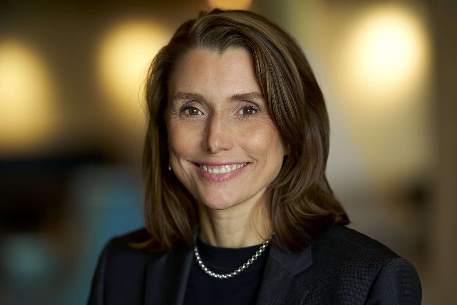 Porträtfoto von Julia Sturmfels, Pressekontakt bei BRITA, vor warmem, unscharfem Bürohintergrund.