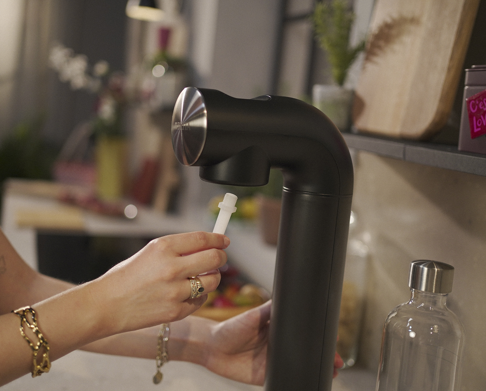 Frau setzt Düse BRITA sodaONE ein Eine Frau setzt eine Düse in einen schwarzen sodaONE ein
