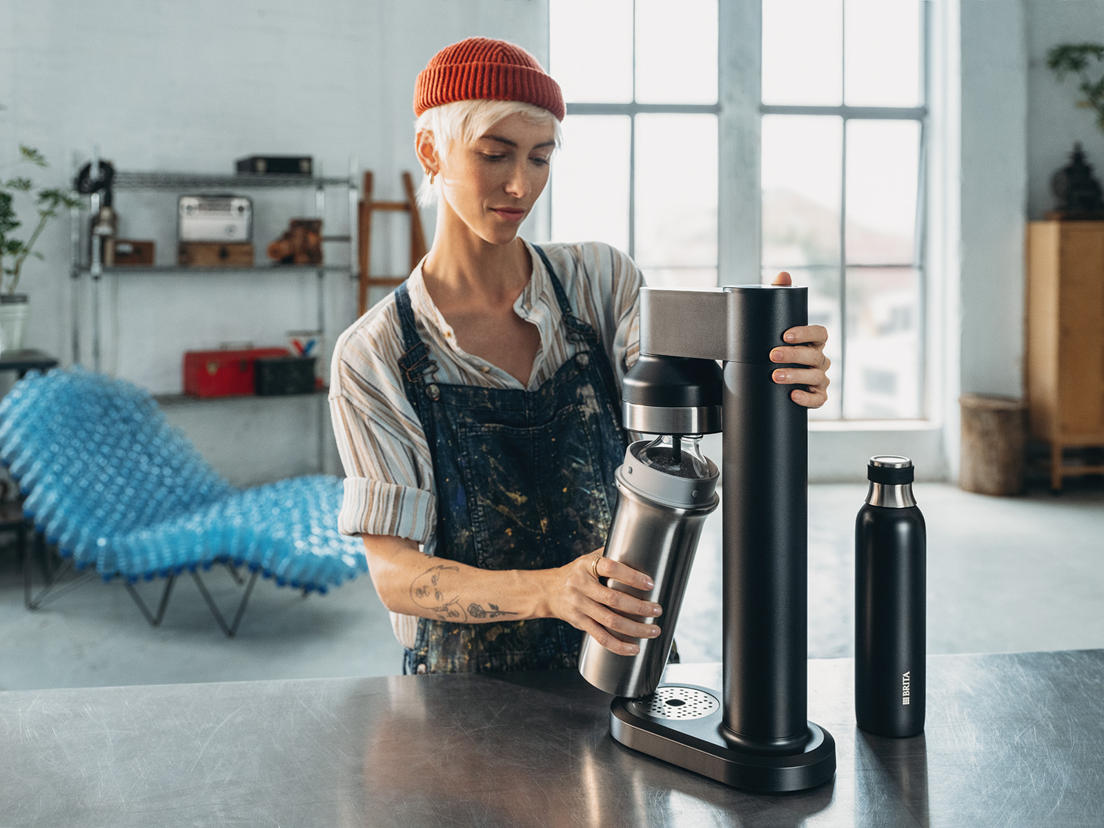 Frau schraubt Flasche in BRITA sodaTRIO. Eine Frau schraubt eine Flasche in den BRITA sodaTRIO Wassersprudler.