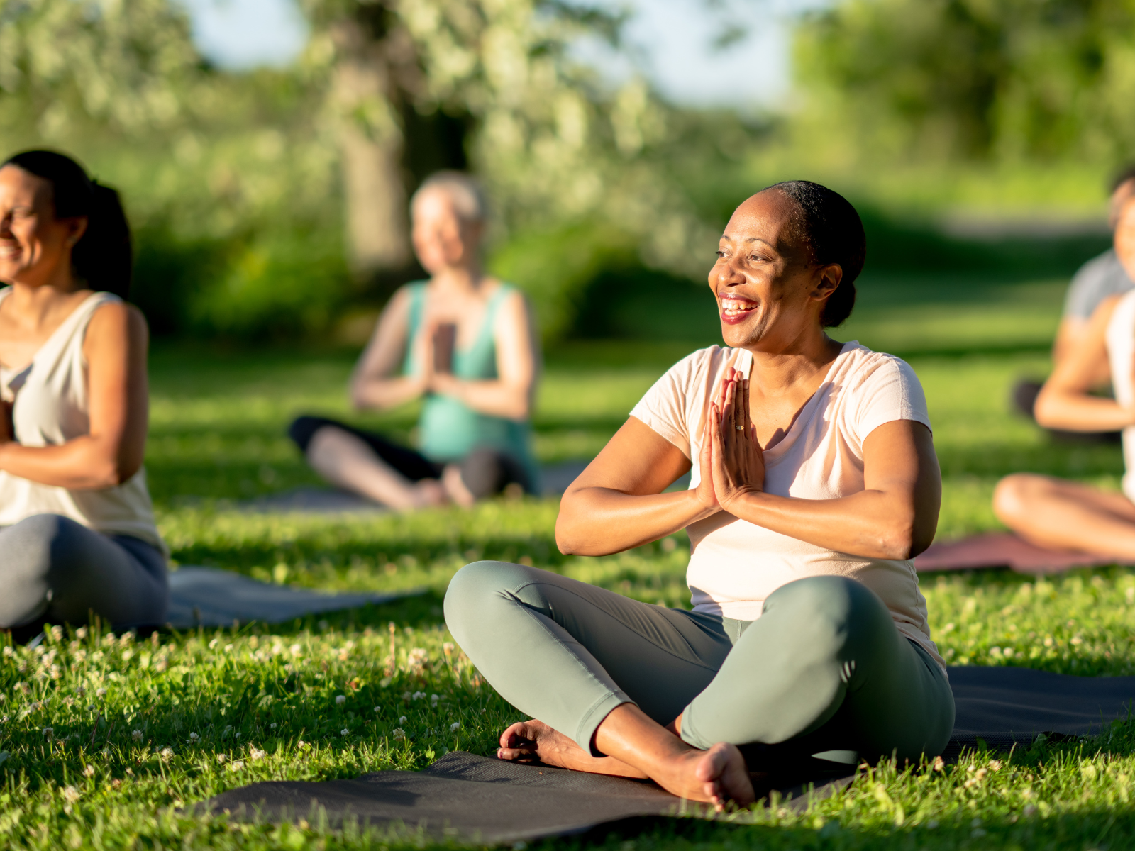 Frauengruppe macht Pilates im Freien und fokussieren sich auf die Ausübung