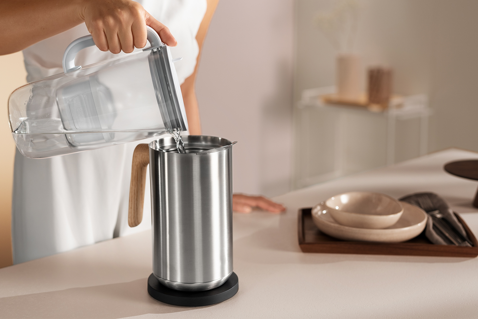 Ein silberner Wasserkocher wird mit Wasser gefüllt Ein silberner Wasserkocher wird mit dem BRITA Tischwasserfilter Glas mit Wasser befüllt