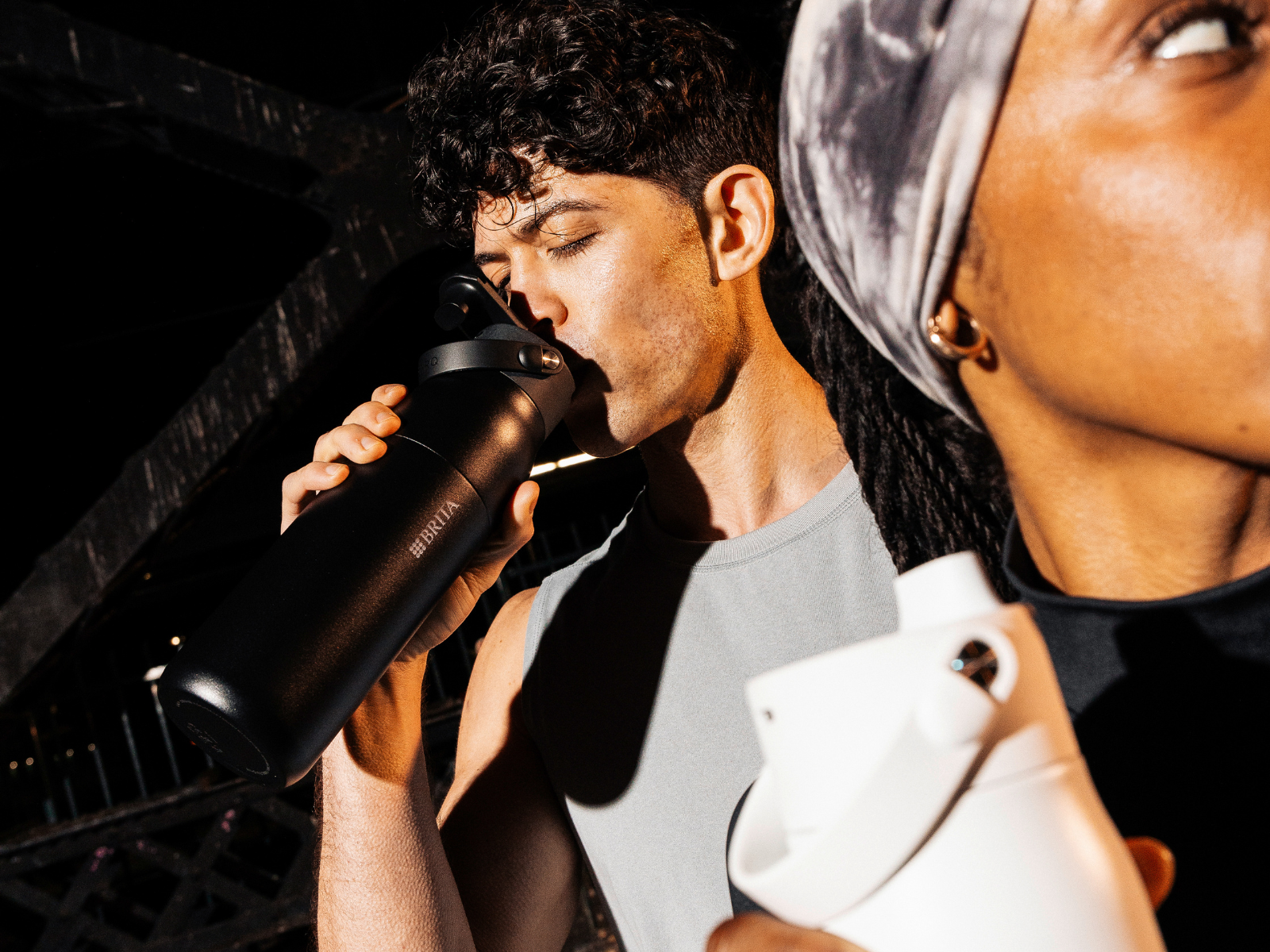 Running Hydration Trinkpause beim Joggen: Mann trinkt aus der BRITA LARQ Trinkflasche