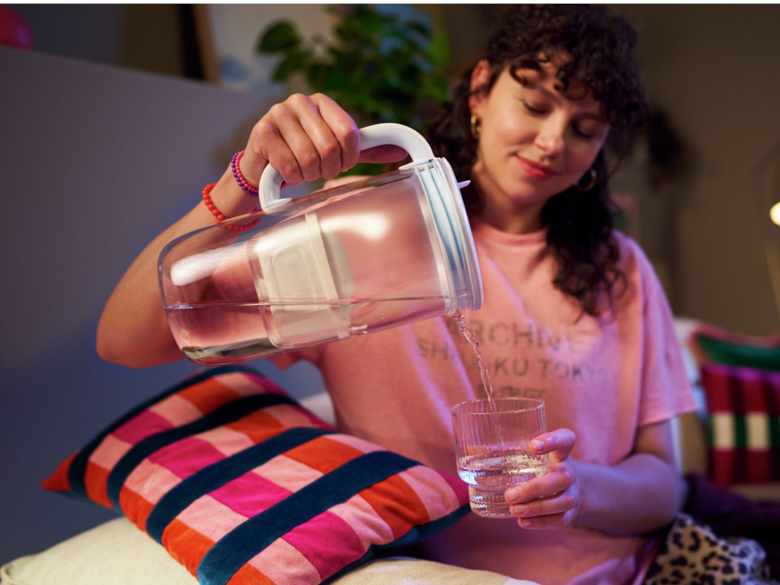 BRITA Wasserfilter-Kanne aus Glas Frau füllt Wasser aus der BRITA Glas Wasserfilterkanne in ein Glas
