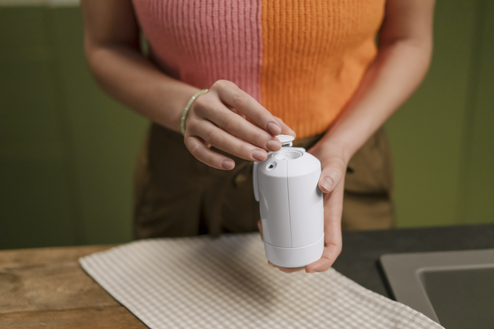 Frau schraubt den BRITA ON TAP Pro V-MF zusammen Eine Frau schraubt in einer Küche den BRITA ON TAP Pro V-MF zusammen