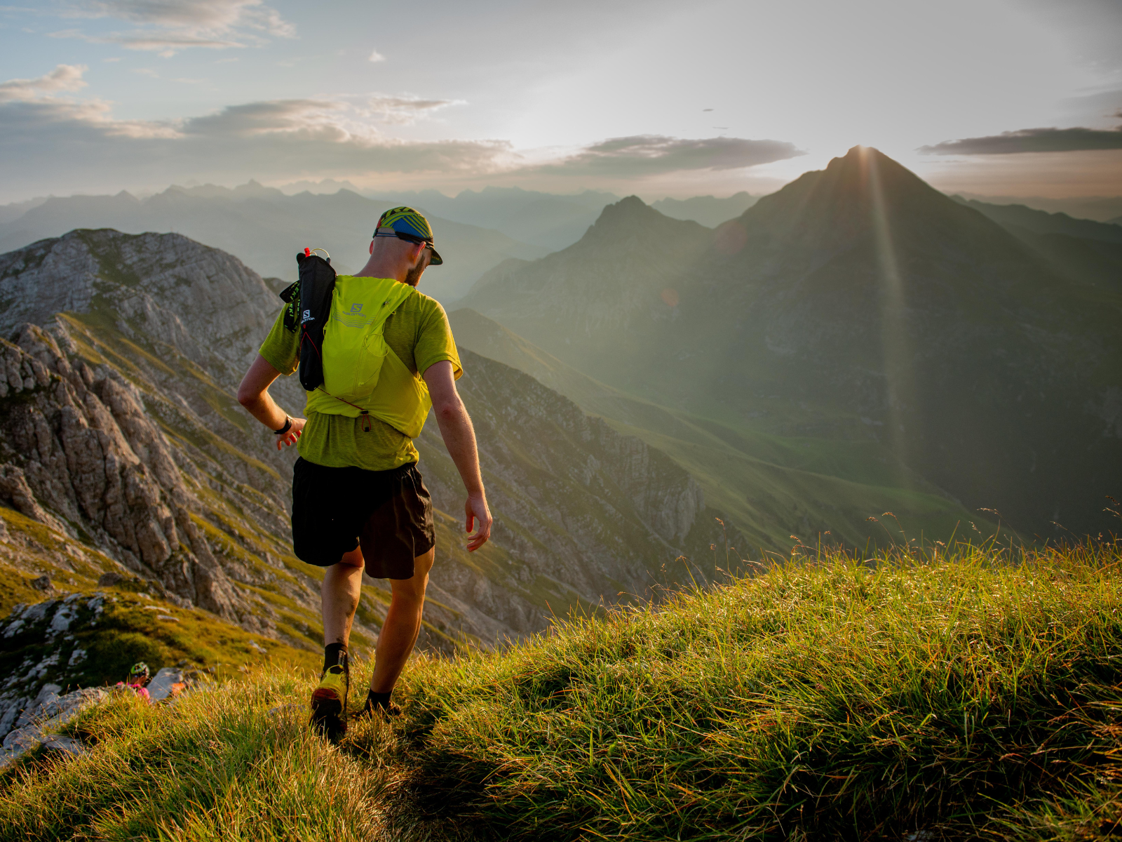 Trailrunning: Equipment Trail Runner mit Laufweste, Kappe läuft durch die Berglandschaft