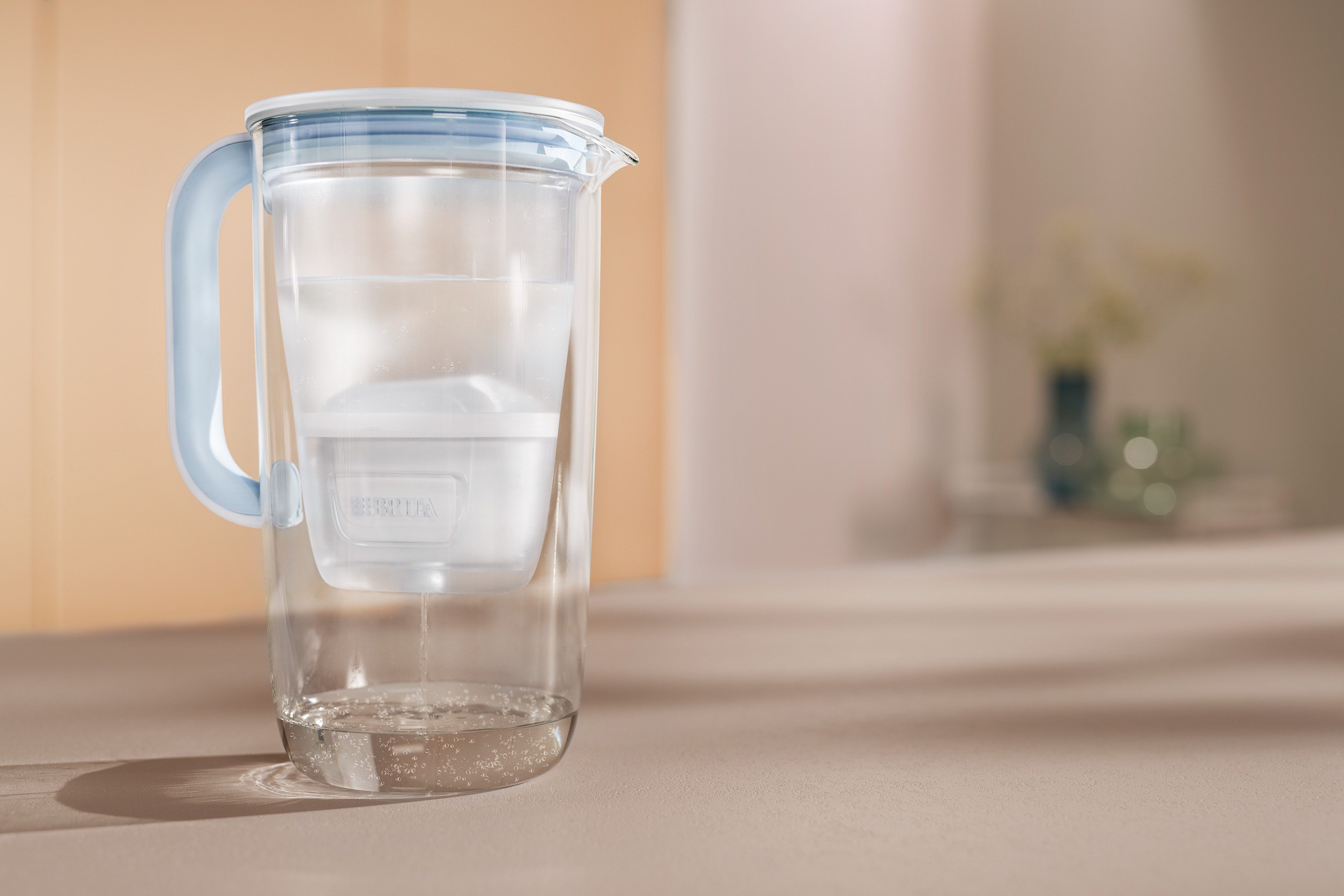 Frau füllt Wasserglas BRITA Tischwasserfilter Glas Eine Frau füllt Ihr Wasserglass mit dem BRITA Tischwasserfilter Glas auf