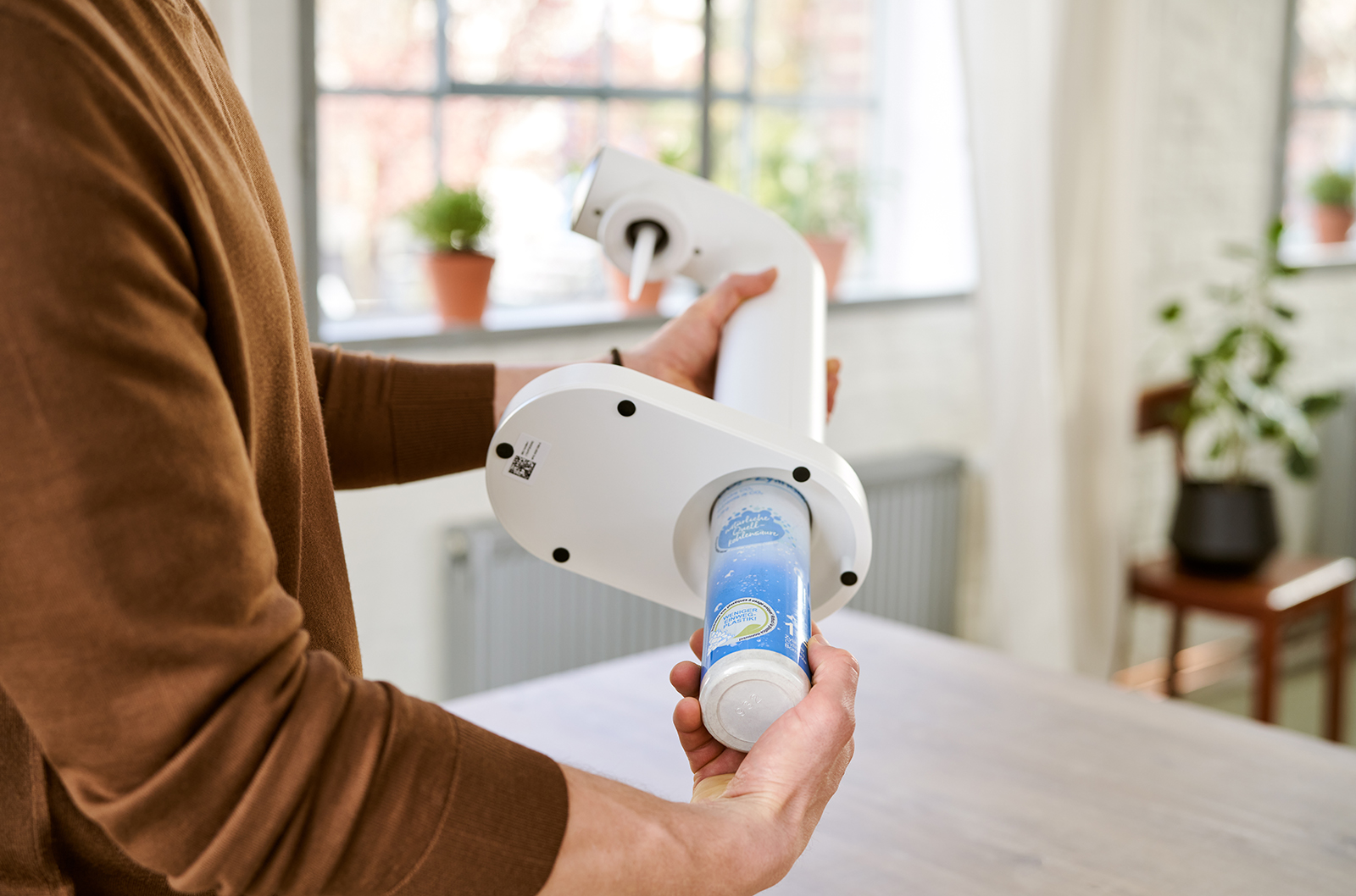 Mann setzt CO2-Zylinder in den BRITA sodaONE ein Ein Mann setzt den CO2-Zylinder in den weißen BRITA sodaONE ein