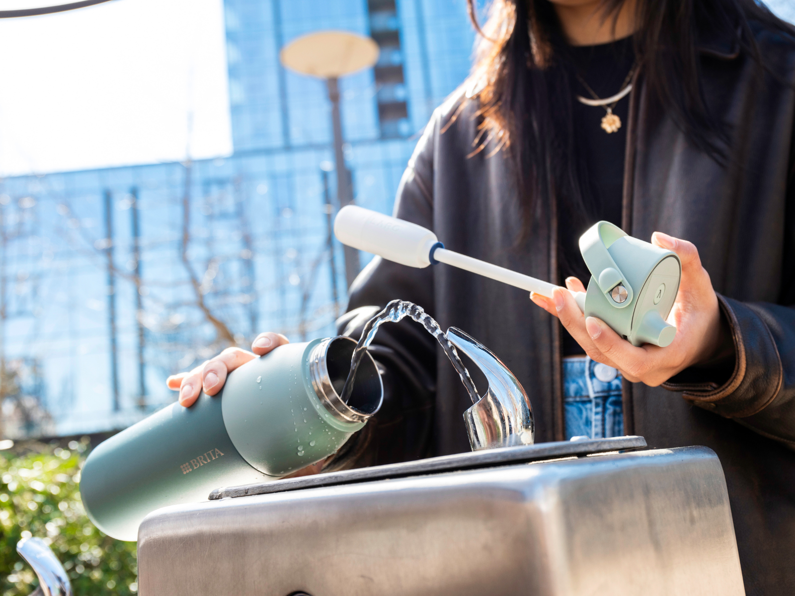 BRITA LARQ Filter-Trinkflasche auffüllen Frau füllt ihre BRITA LARQ Filter-Trinkflasche mit klarem Wasser auf