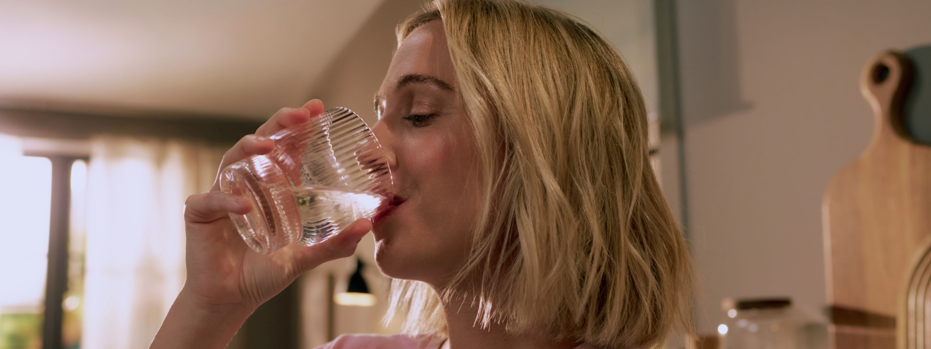 Frau trinkt gefiltertes Wasser aus einem Glas