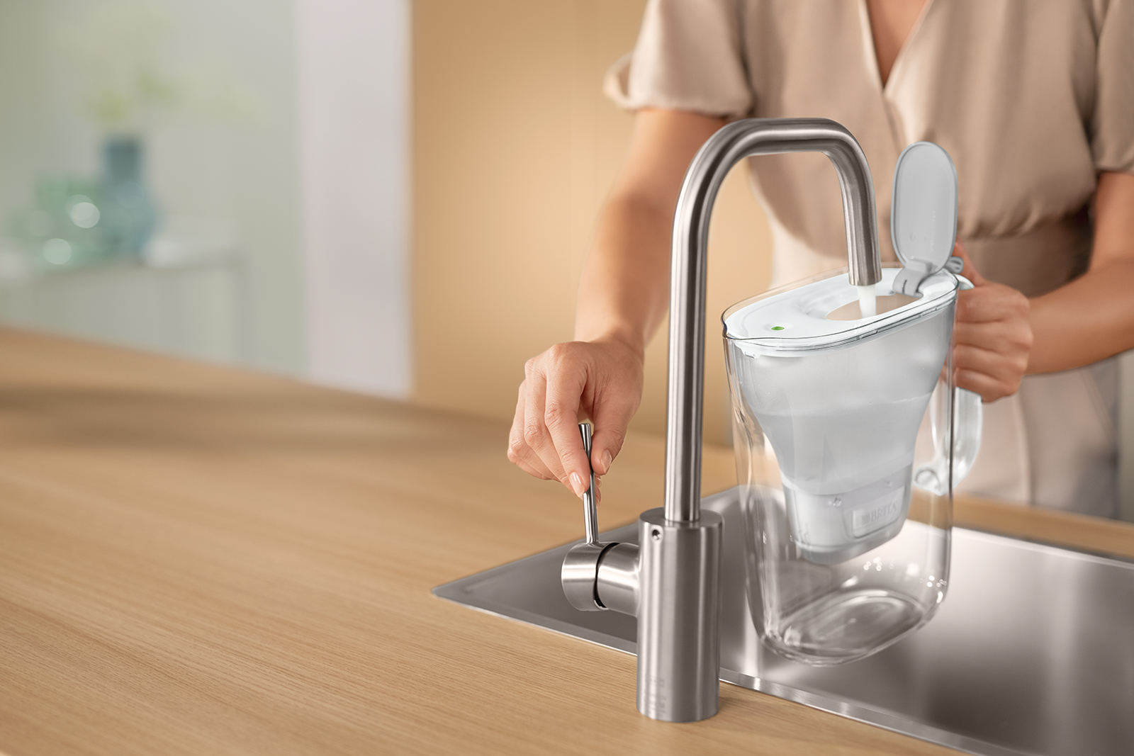 BRITA Style wird am Wasserhahn befüllt. BRITA Style in Grau wird am Wasserhahn befüllt.