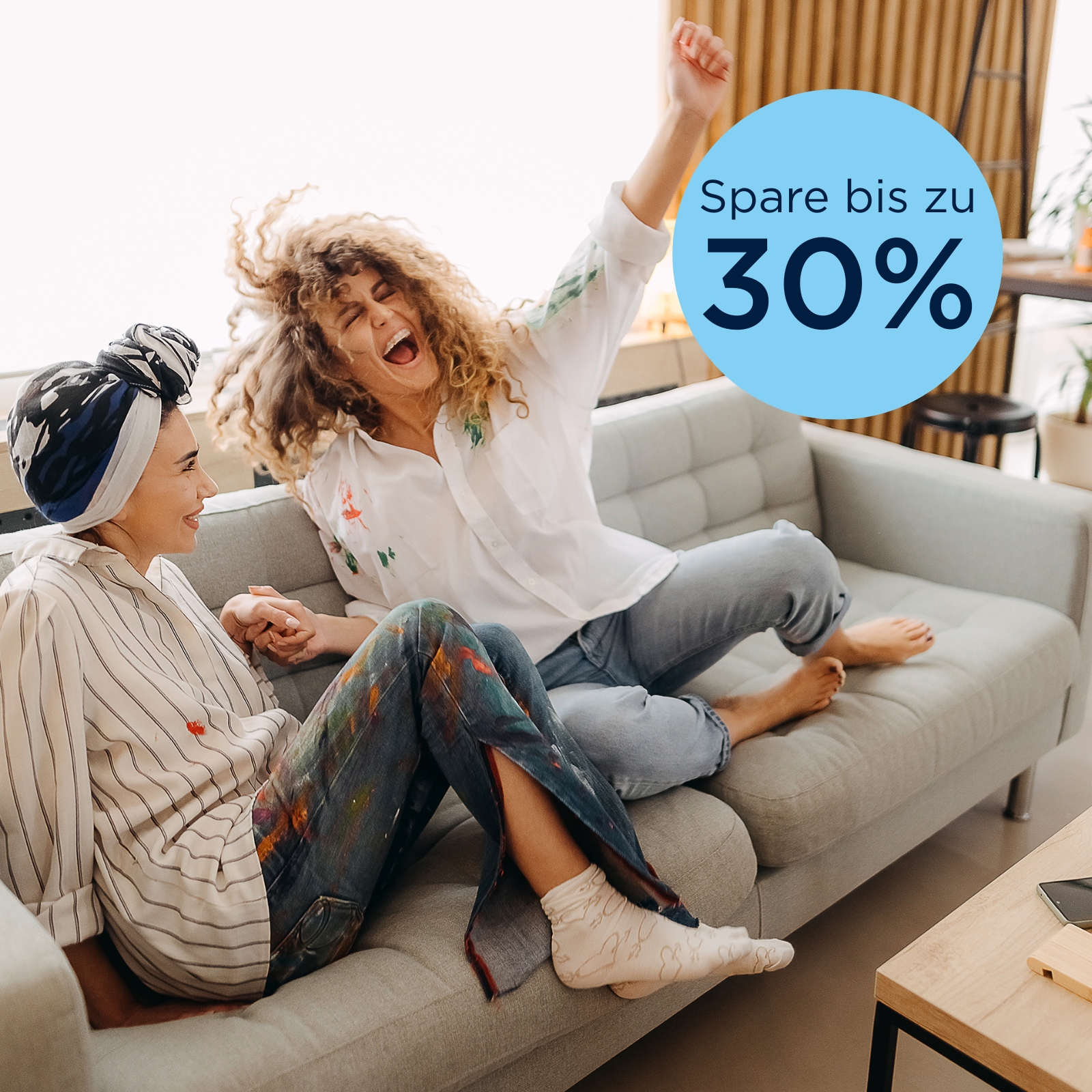 Zwei junge Frauen jubeln auf der Couch