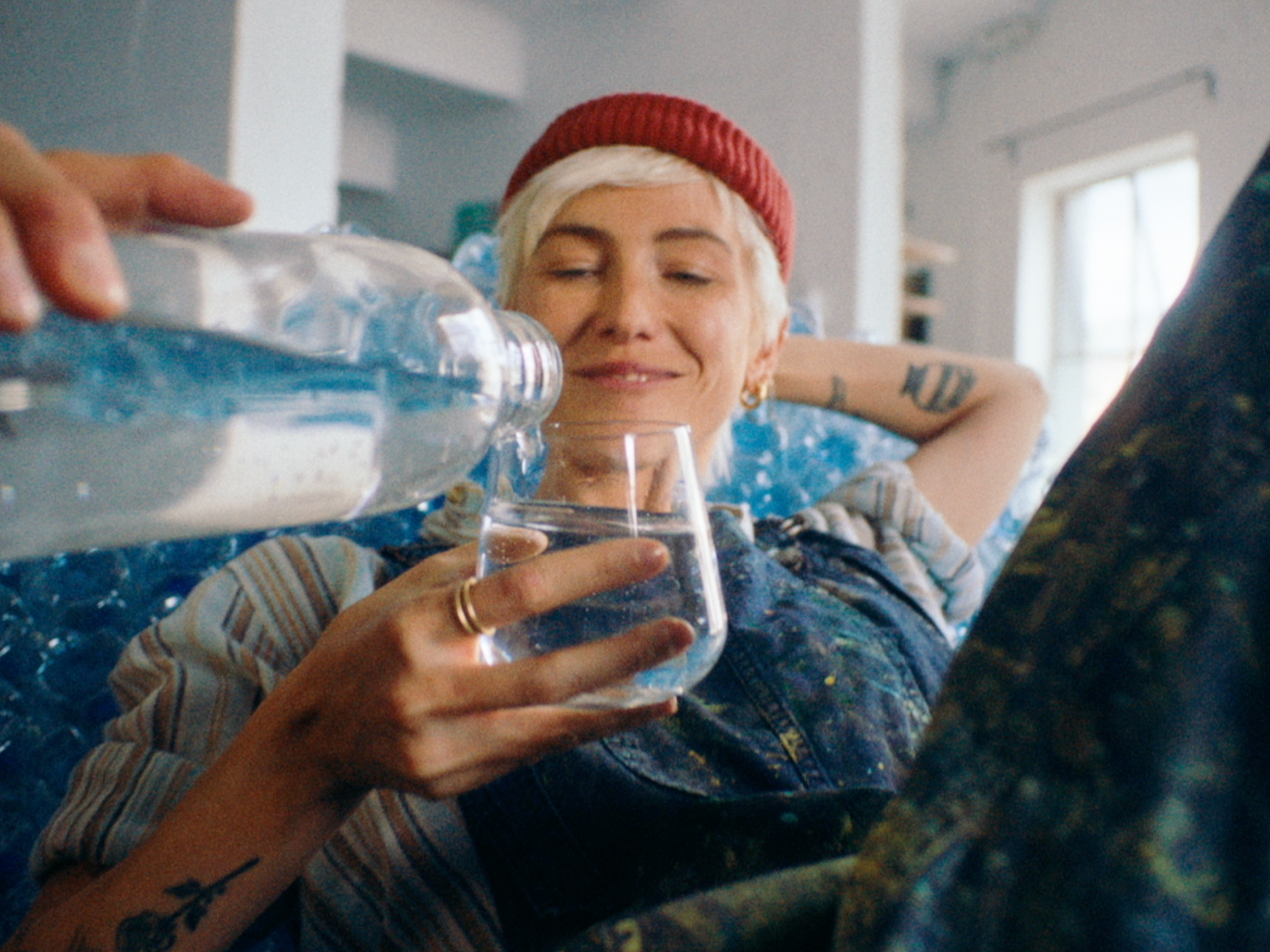 Frau in roter Mütze trinkt ein Glas BRITA gefiltertes Wasser