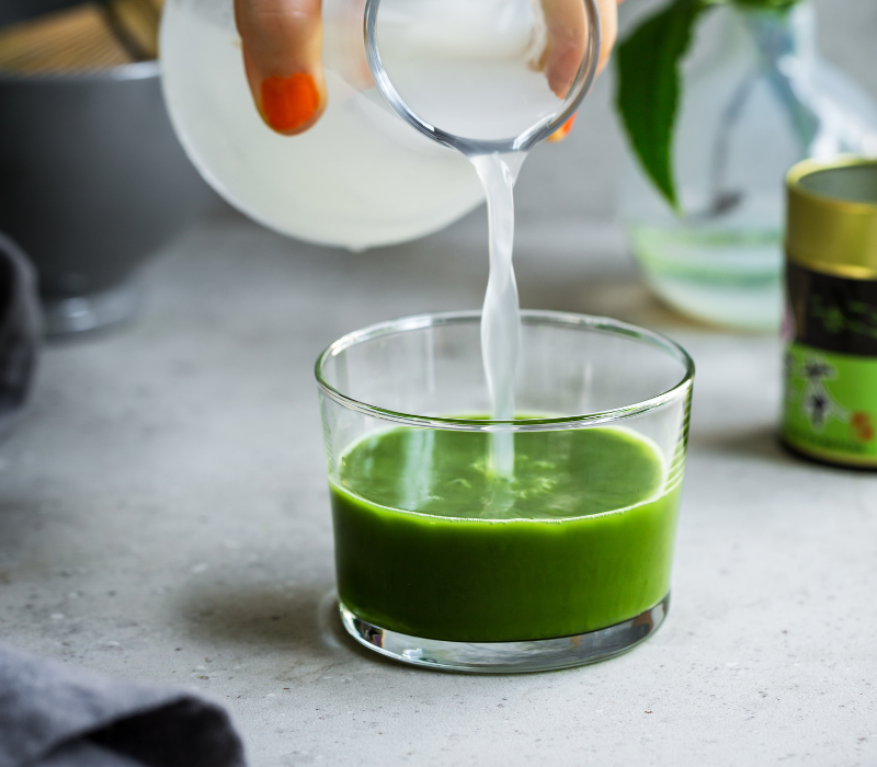 Matche meets gefiltertes Wasser Gefiltertes Wasser mit Limettensaft und Agavendicksaft angereichert wird mit Matcha vermengt