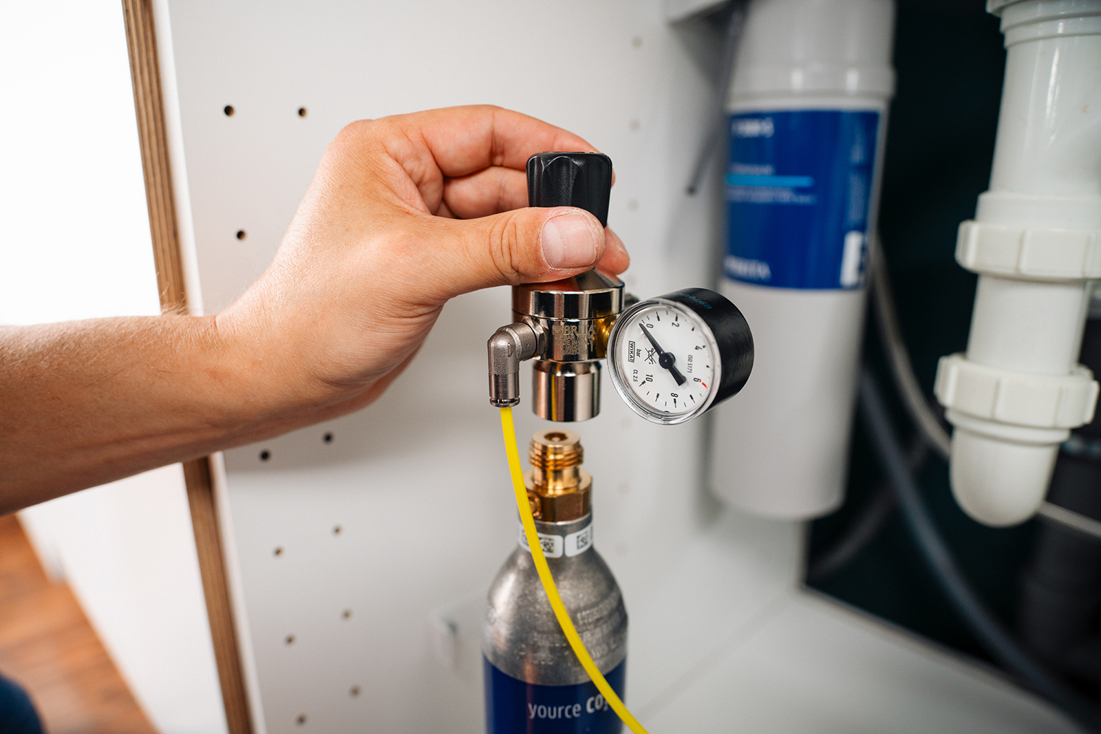 Detailansicht der Installation eines BRITA yource Geräts unterhalb der Spüle mit CO2-Zylinder
