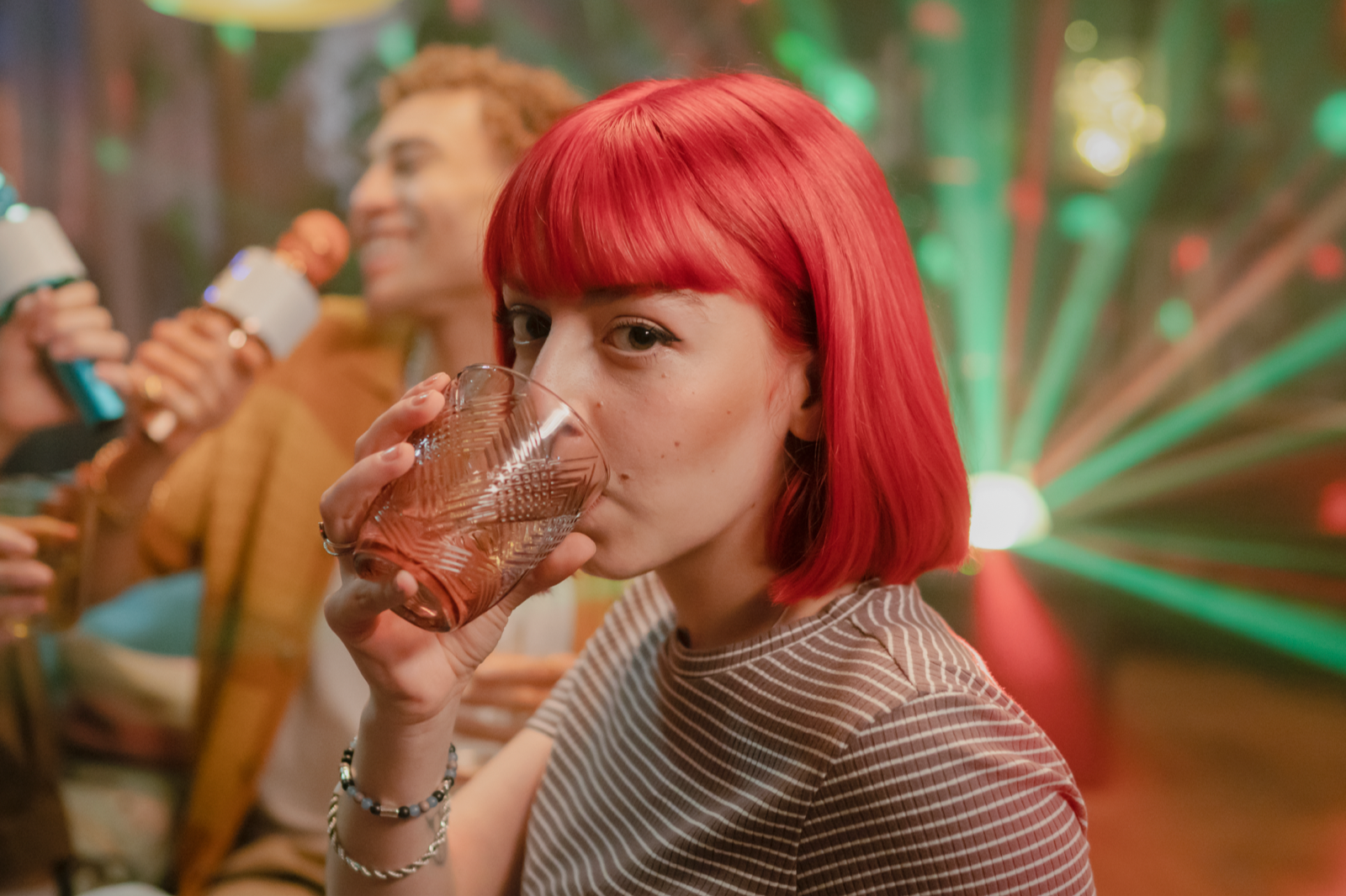 Frau mit roten Haaren trinkt ein Glas BRITA gefiltertes Wasser